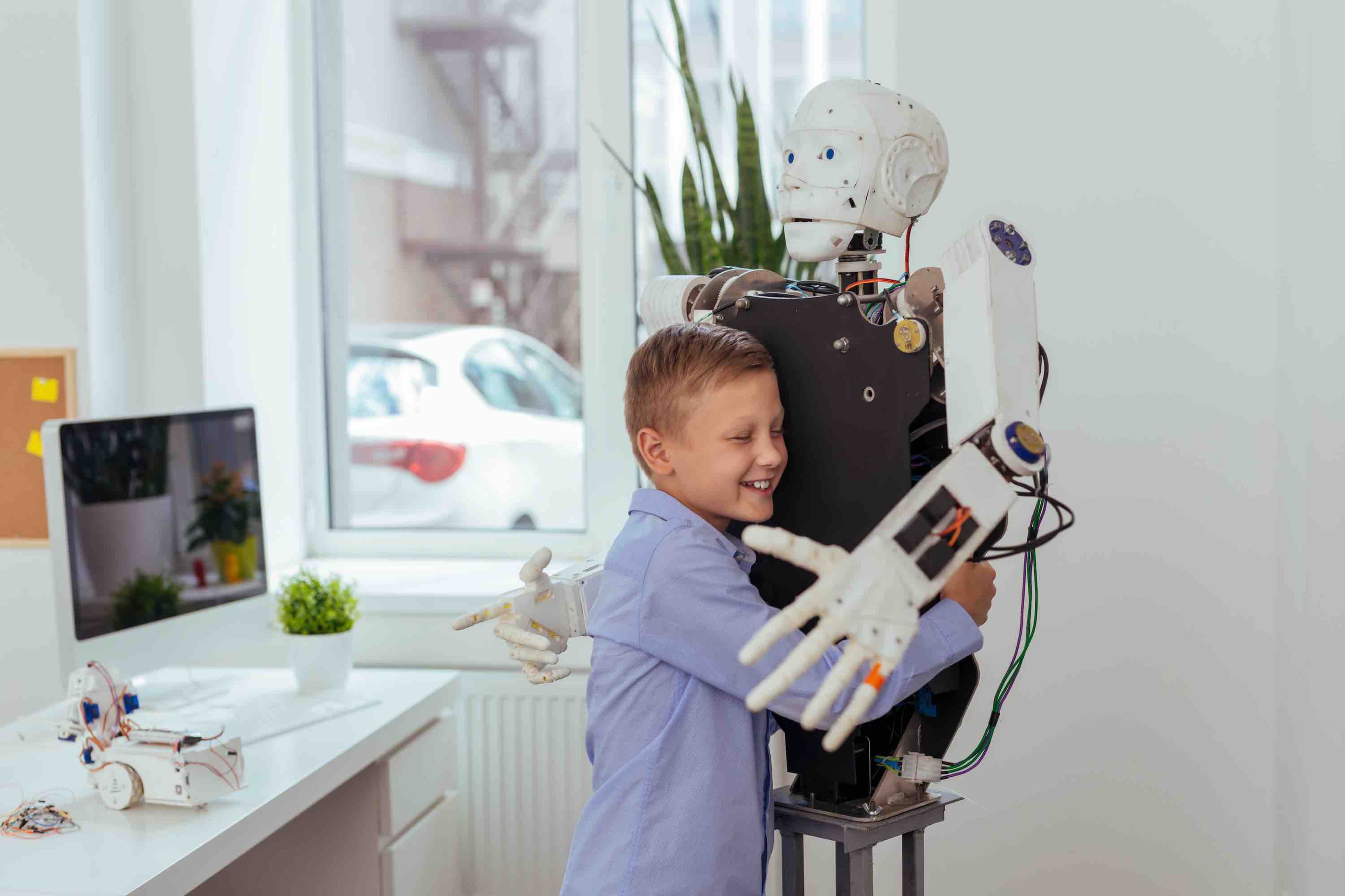 Un niño abraza a un robot.