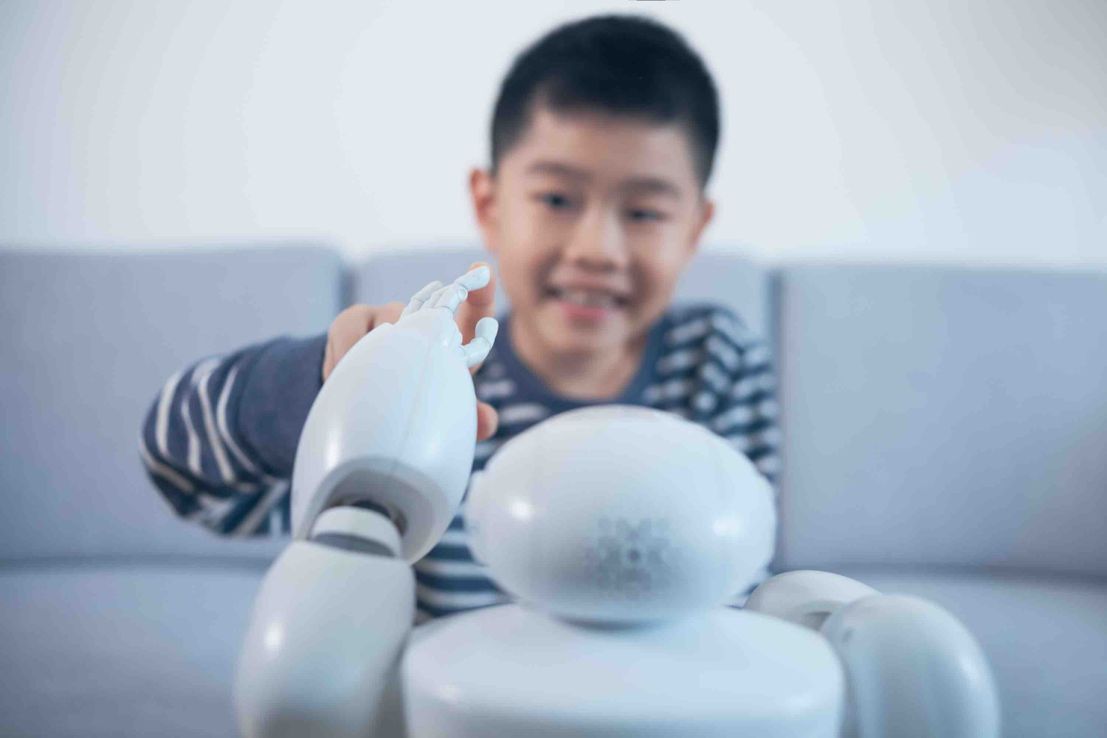 Un niño interactúa con un robot.