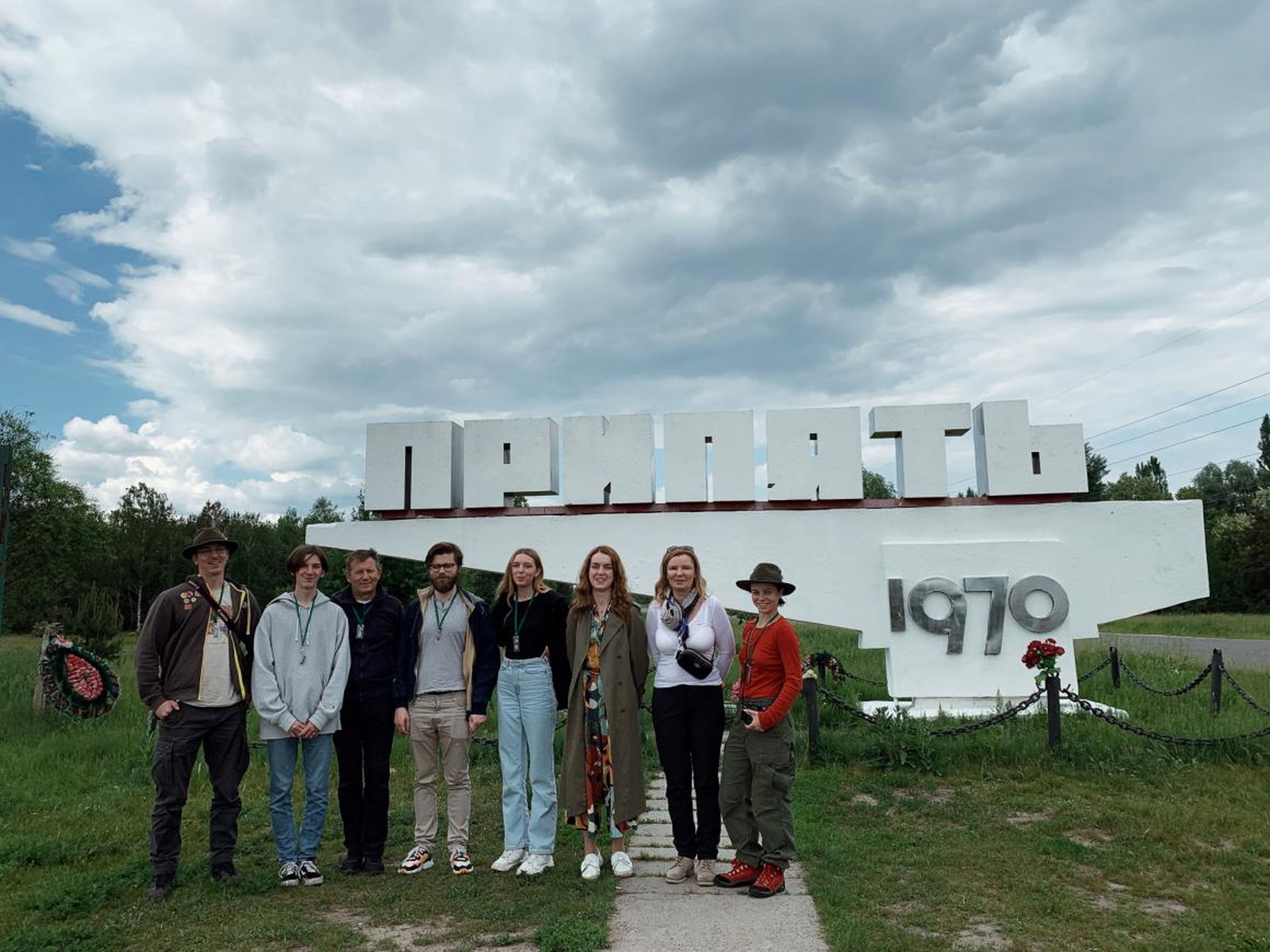Czub y compañeros de viaje frente a un cartel en Pripyat.
