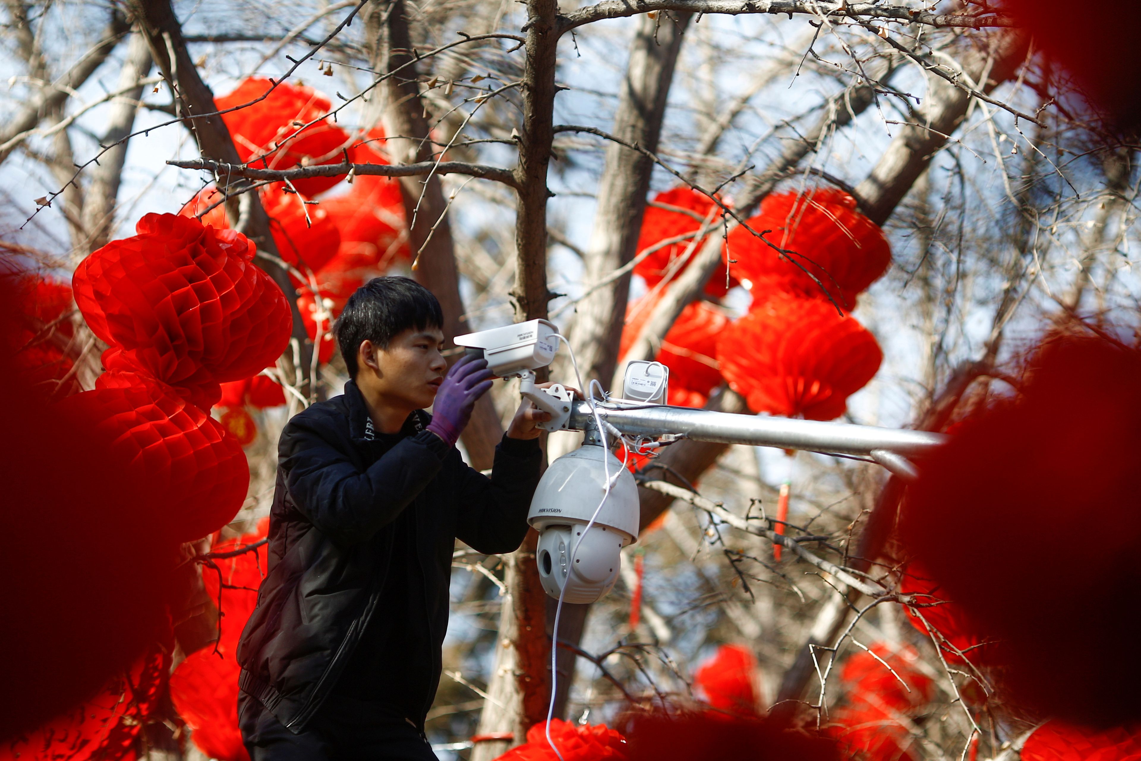 Un trabajador coloca una cámara de vigilancia en Pekín