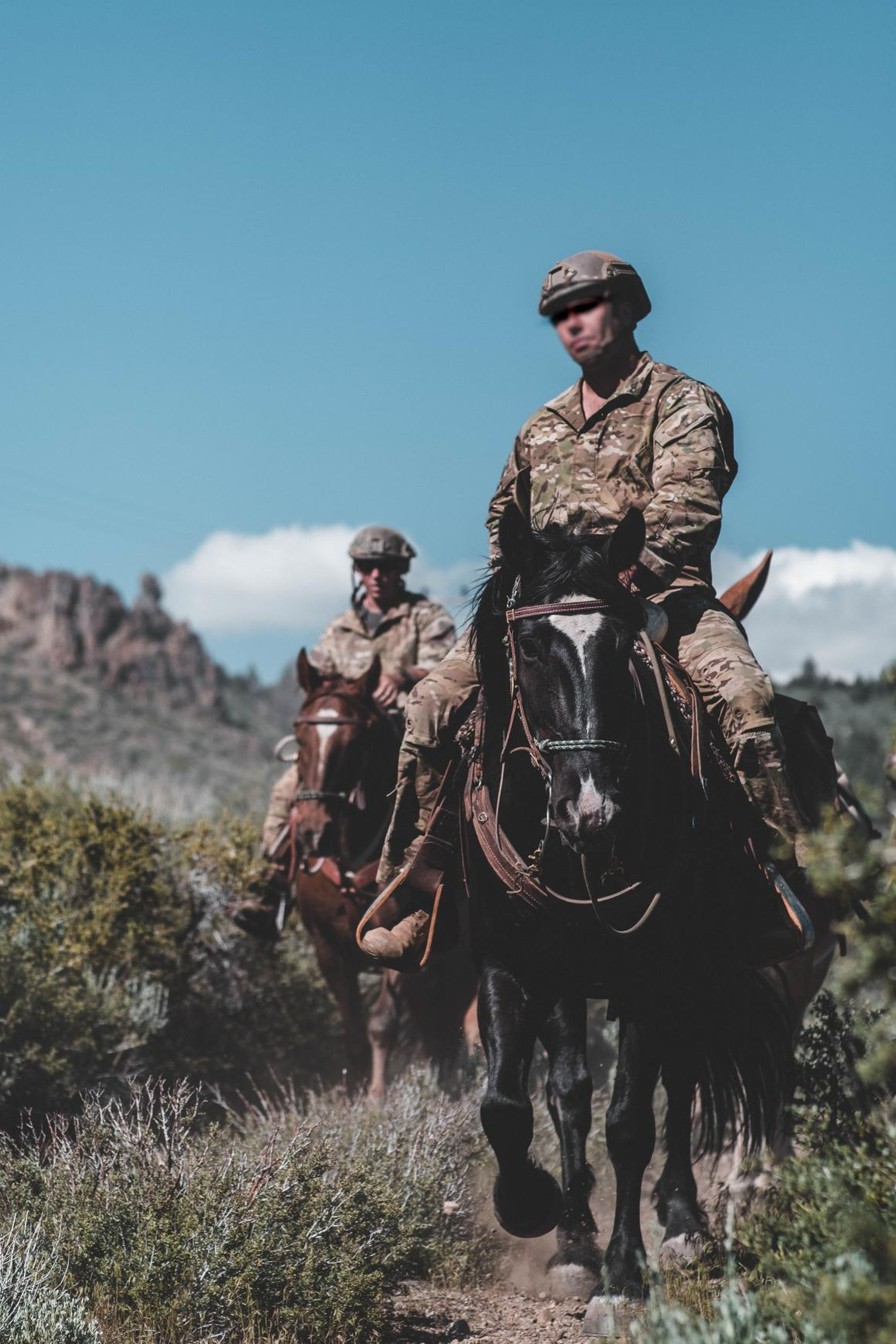Soldados de Operaciones Especiales del Ejército de los EE. UU. con el 2° Batallón, 7° Grupo de Fuerzas Especiales (Aerotransportadas) montan a caballo por un sendero durante el Curso de Equitación de las Fuerzas de Operaciones Especiales (SOF).