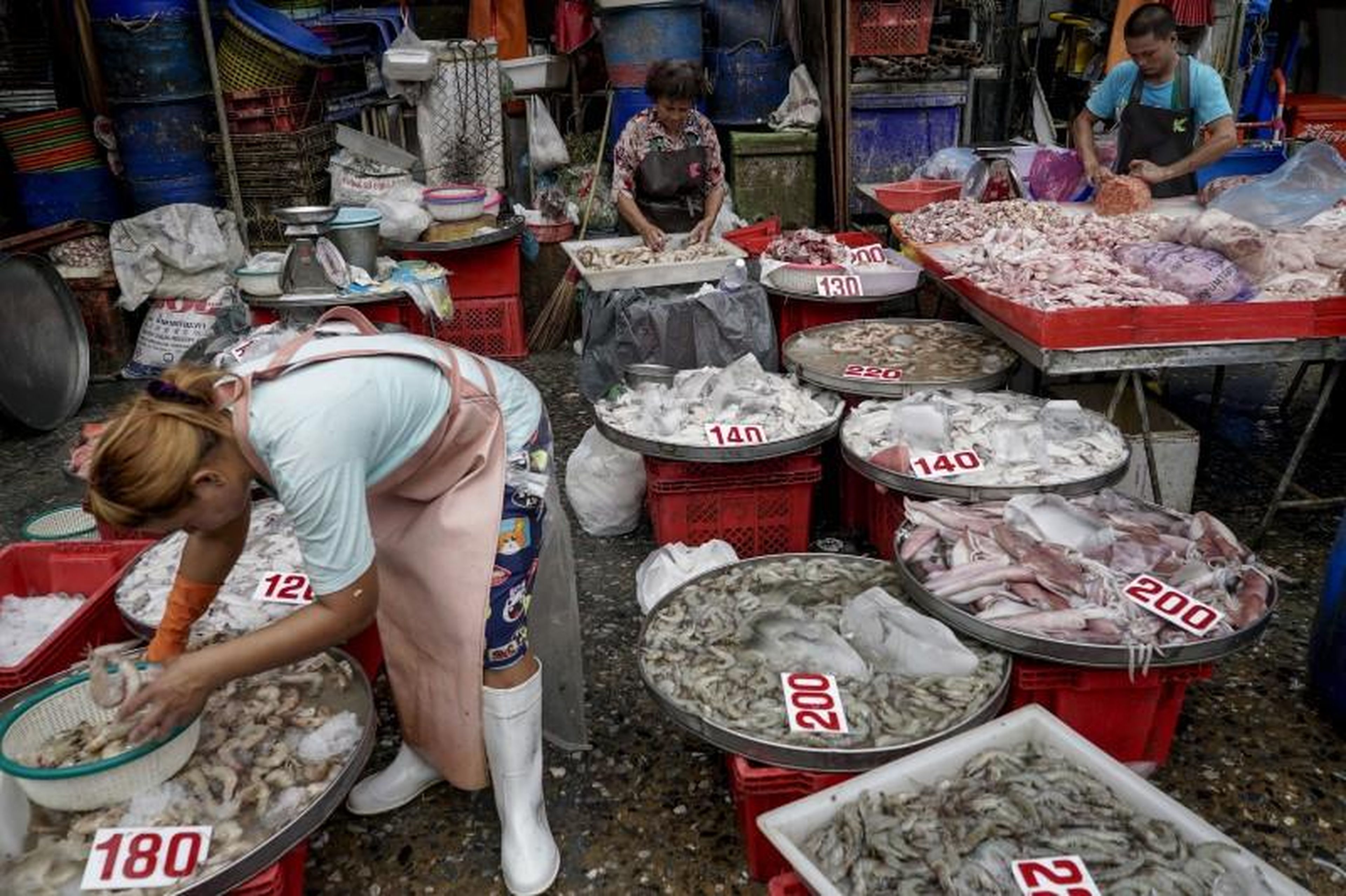 Los vendedores clasifican pescado y otros mariscos en un mercado en Bangkok, Tailandia, el 31 de marzo de 2016.