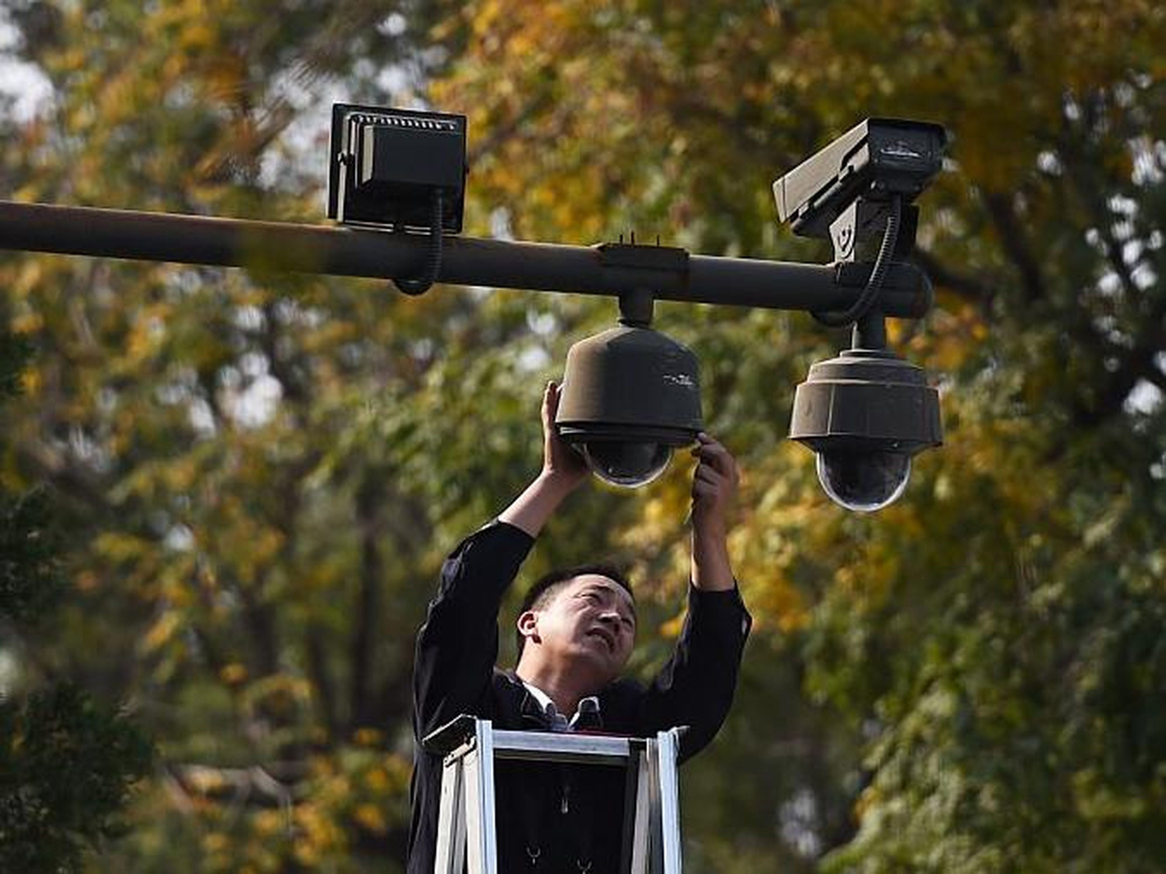 Un trabajador ajusta las cámaras de seguridad en el borde de la Plaza Tiananmen en Beijing el 30 de septiembre de 2014.