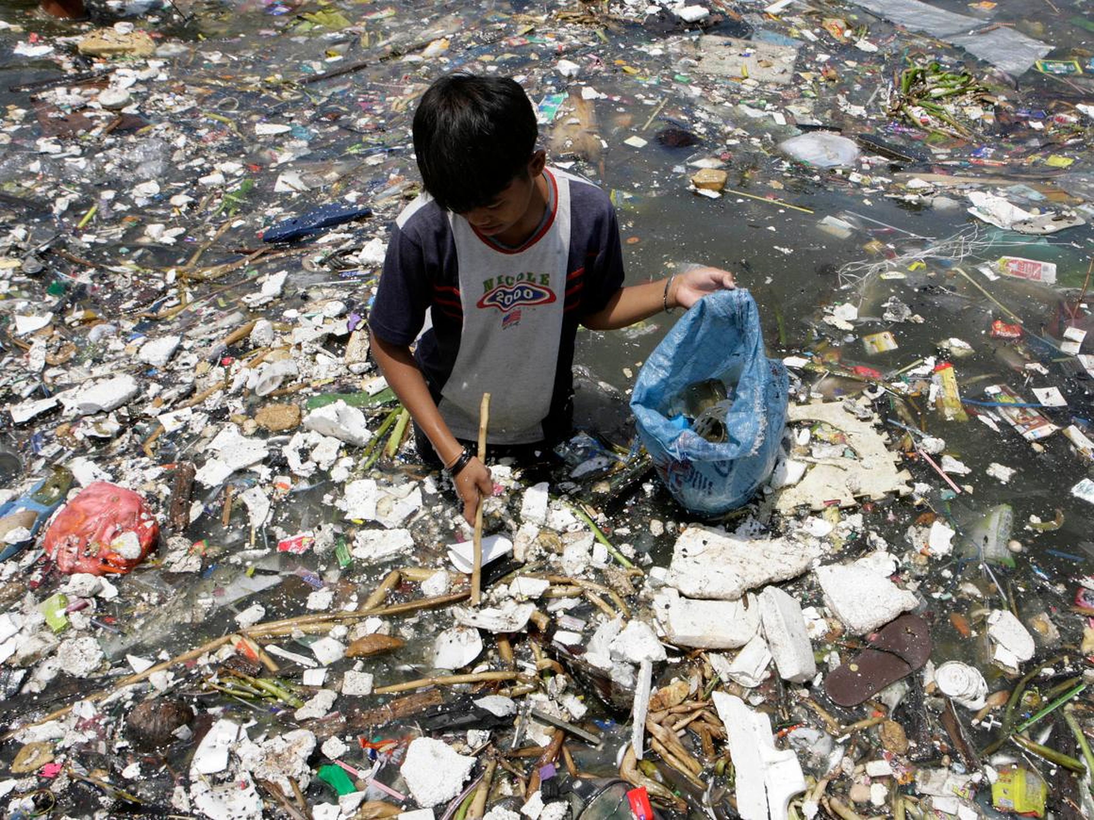 Un niño en Filipinas recoge plástico cerca de la costa