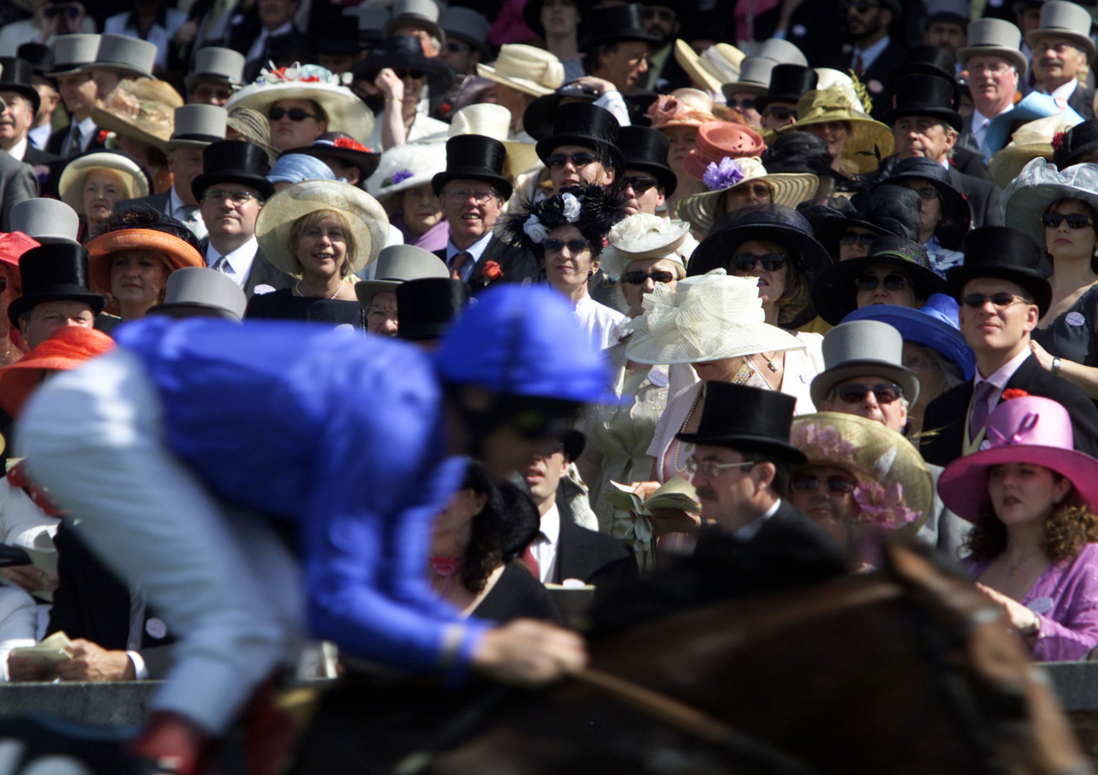 Un grupo de millonarios sigue una carrera de caballos en el hipódromo de Ascot