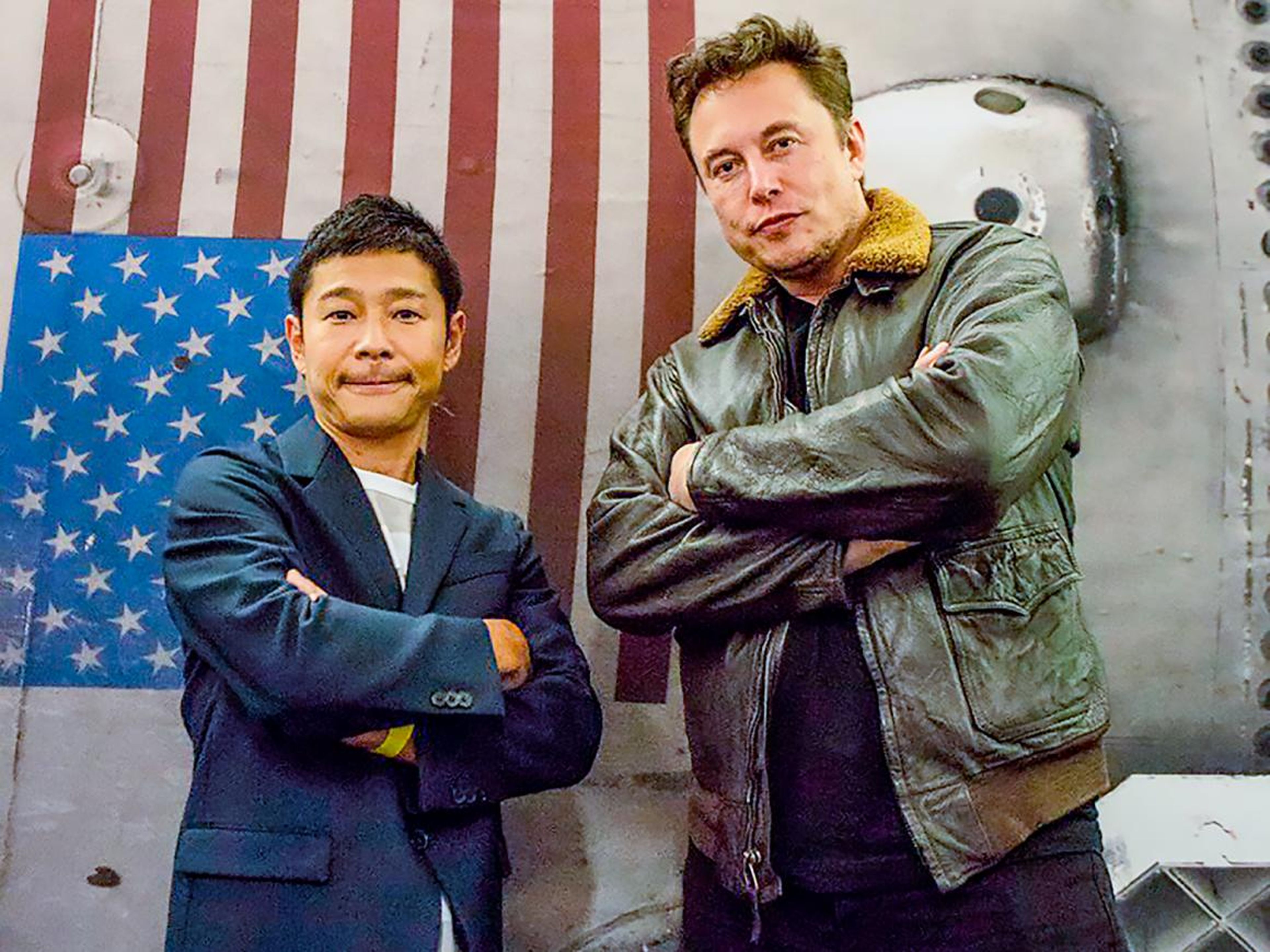 El multimillonario japonés y magnate de la moda Yusaku Maezawa posa con Elon Musk, CEO de SpaceX, frente a una impresión de un cohete Falcon 9 el 18 de septiembre de 2018.