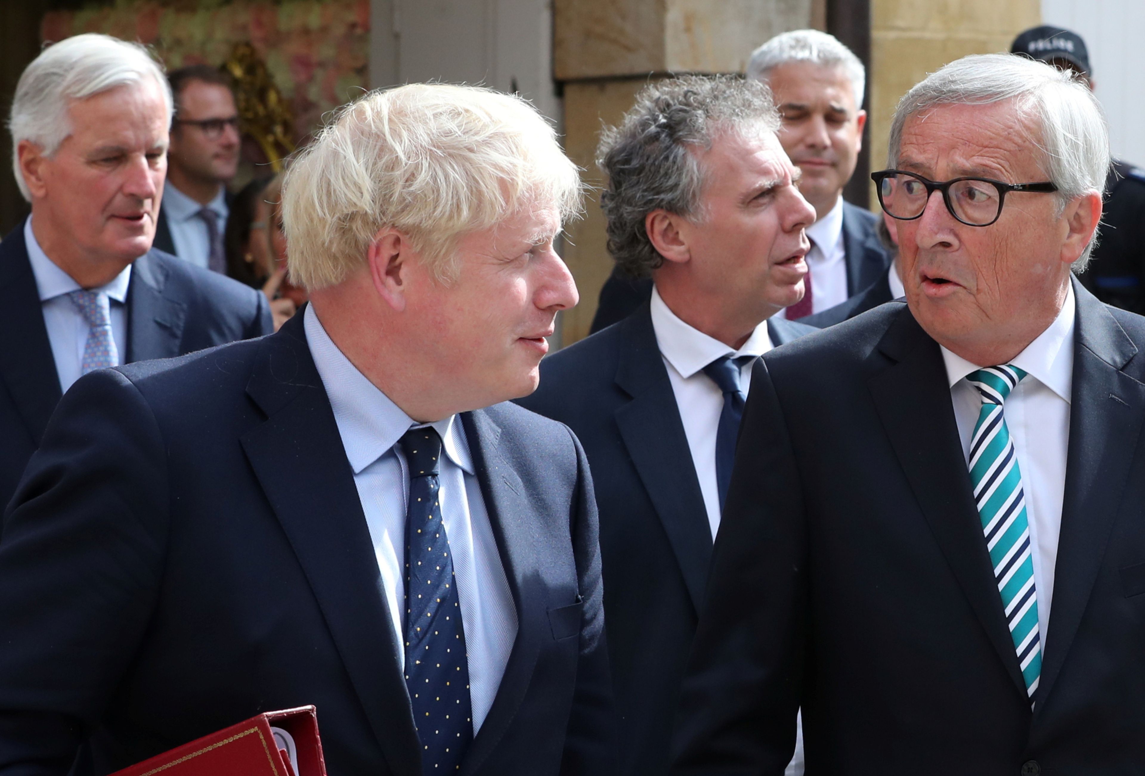 El primer ministro británico, Boris Johnson, y el presidente de la CE, Jean-Claude Juncker, con el negociador de la UE para el Brexit, Michel Barnier, al fondo de la imagen