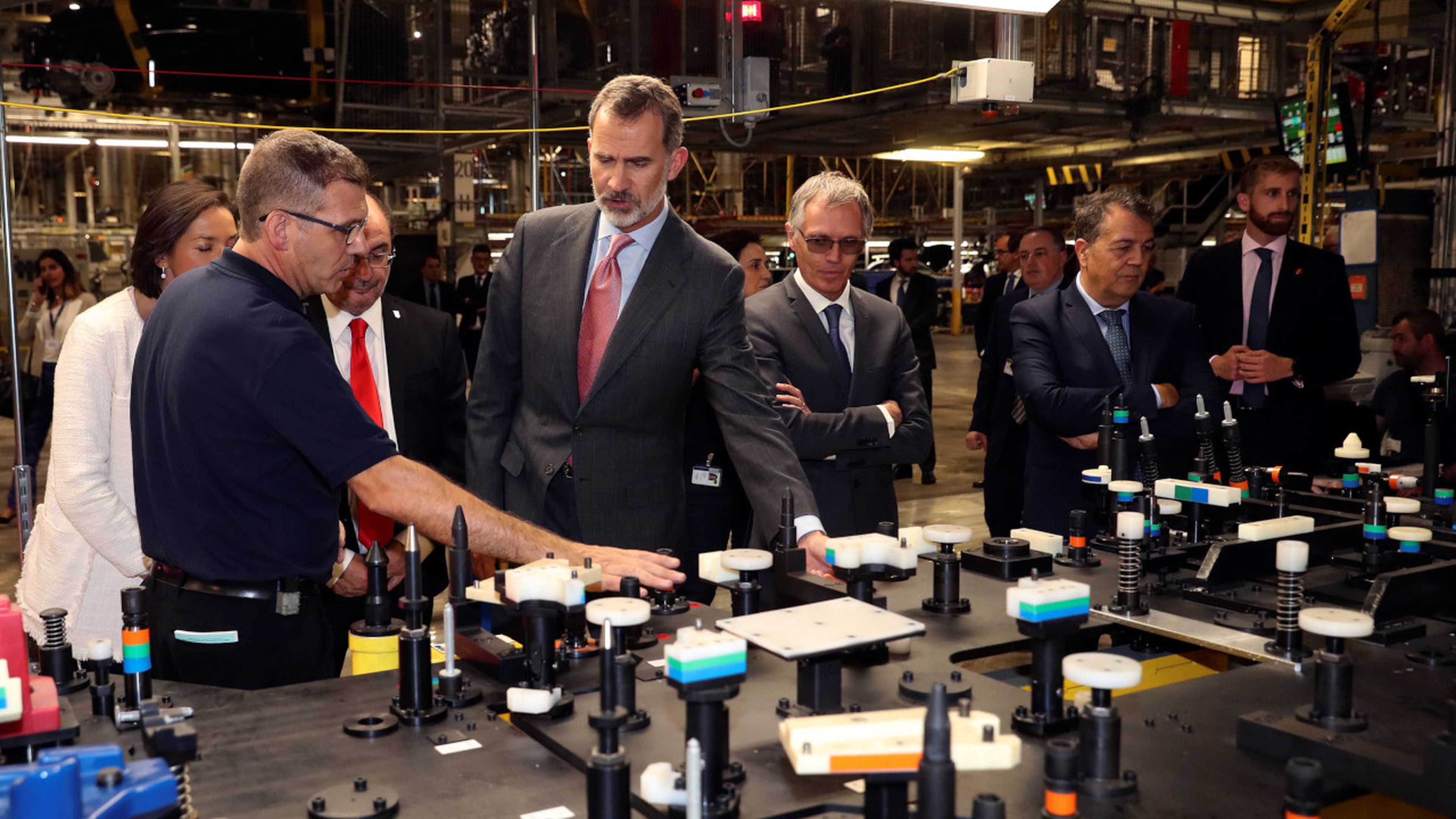 Operarios de PSA Zaragoza explican al Rey las piezas de las que se compone el Opel Corsa.