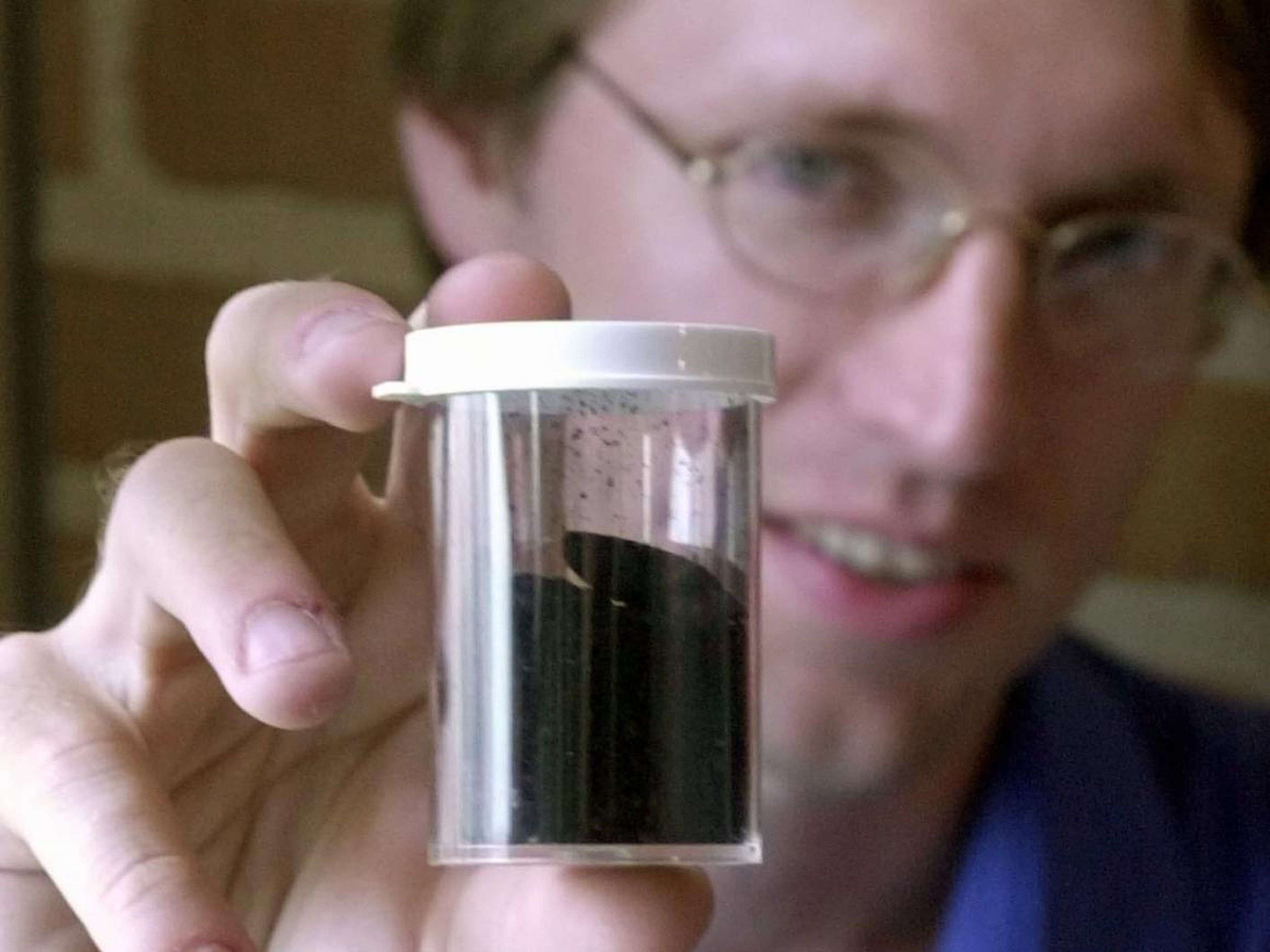 Kevin Ausman, director ejecutivo del centro de nanotecnología biológica y ambiental de la Universidad Rice, sostiene un tubo de nanotubos de carbono, 3 de septiembre de 2002.