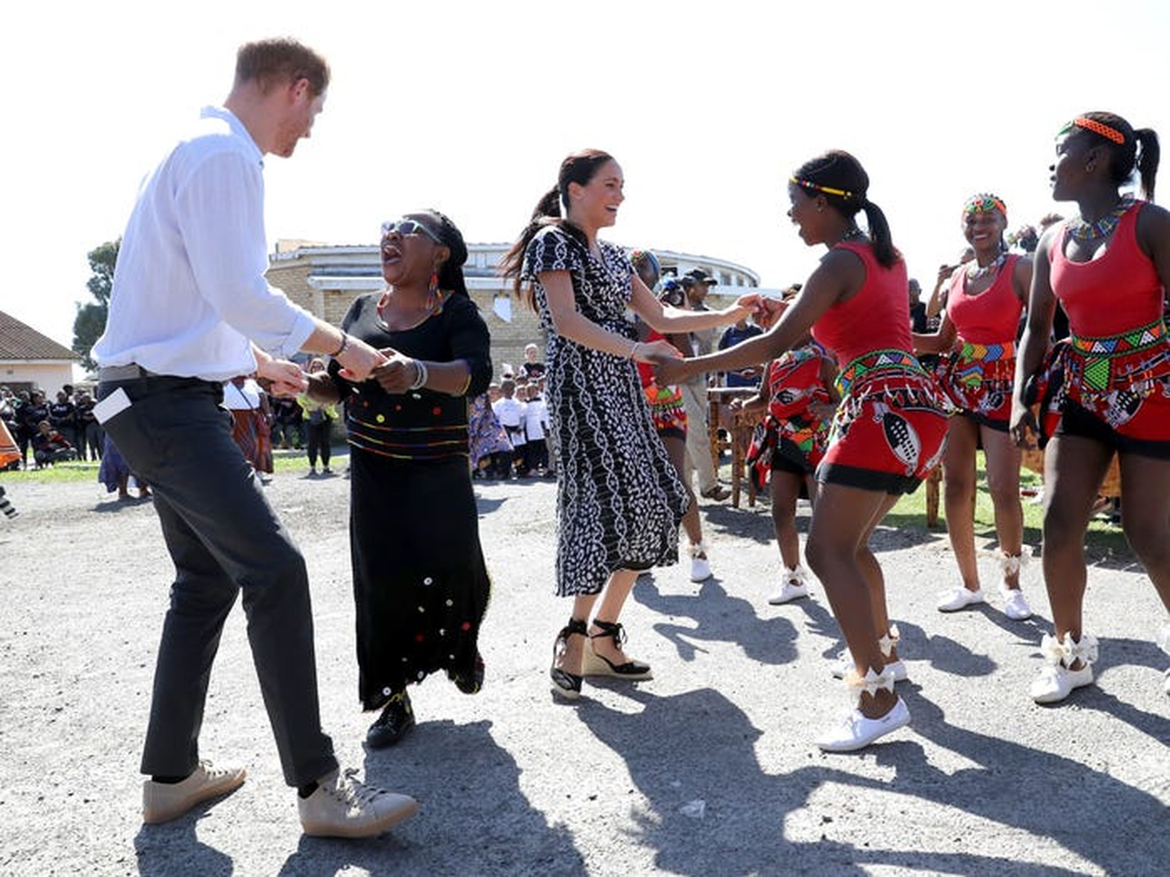 El príncipe Harry y Meghan Markle con gente local.