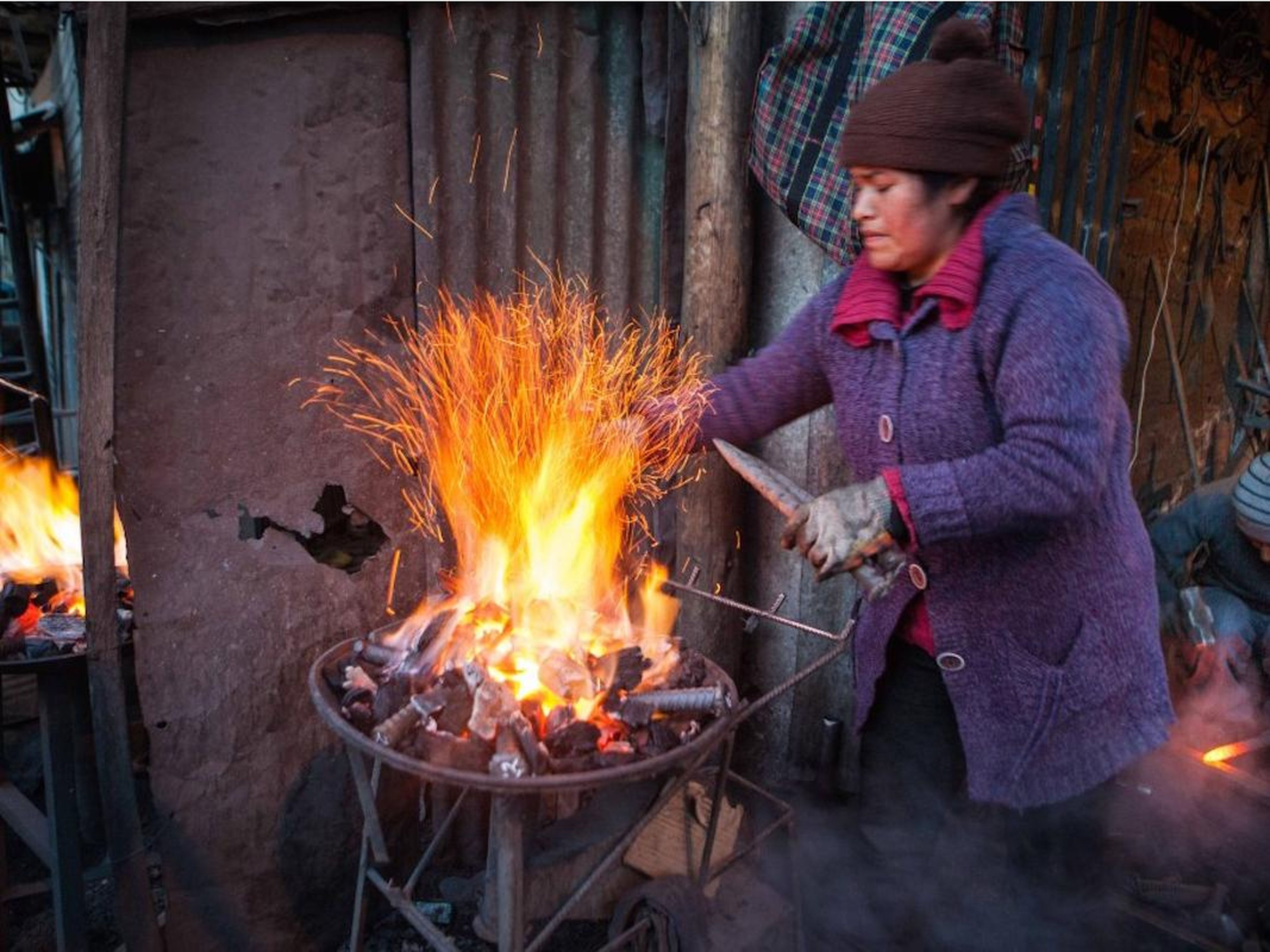 Women aren’t allowed to enter the mines, so they do the outdoor work. This woman is creating the metal parts required to prop up the mining tunnels.