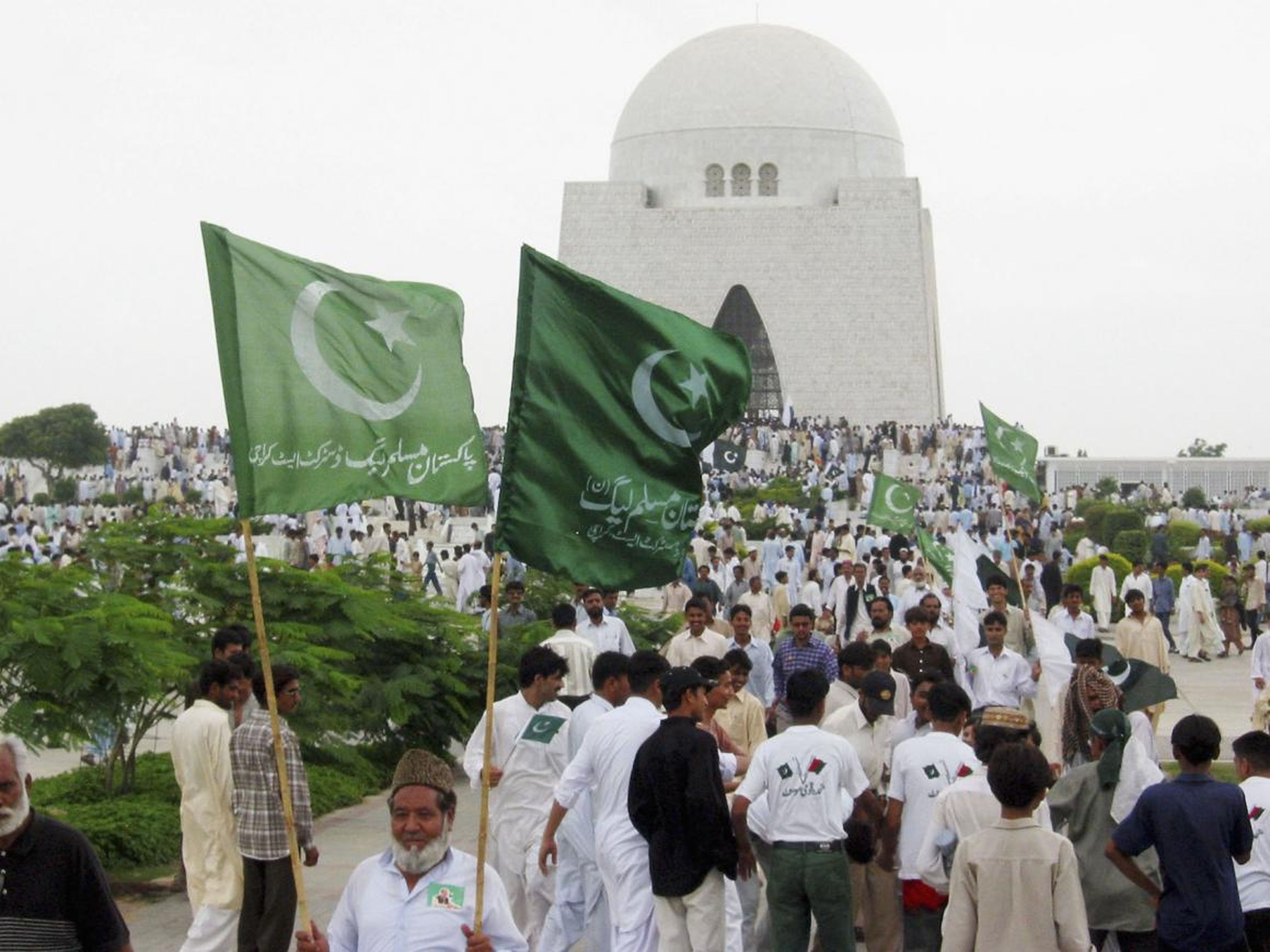 People protesting while carrying the flags of Pakistan in 2018.