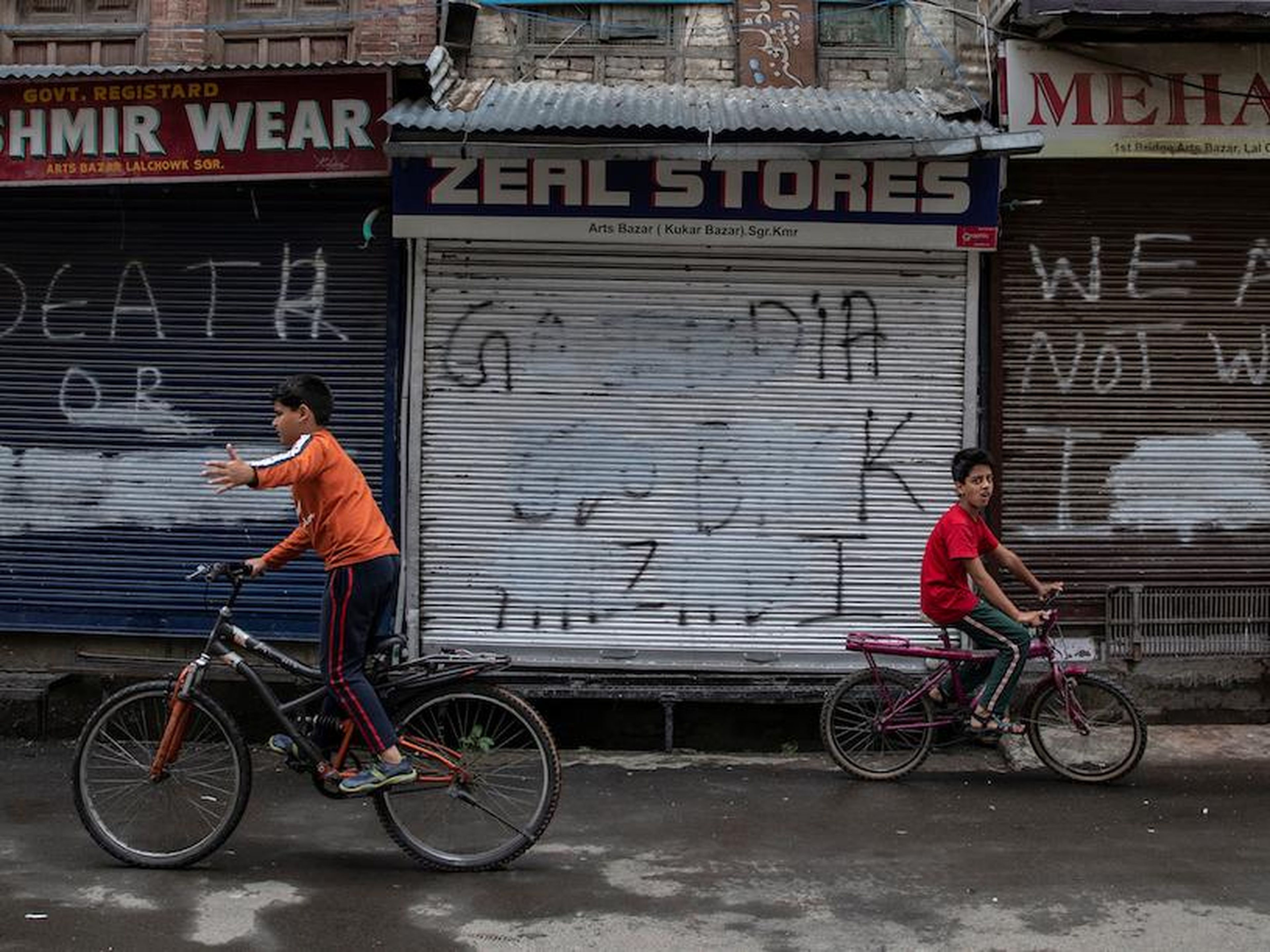Kashmiri boys cycle in an empty street during restrictions in Srinagar, Jammu and Kashmir state, in August 2019.