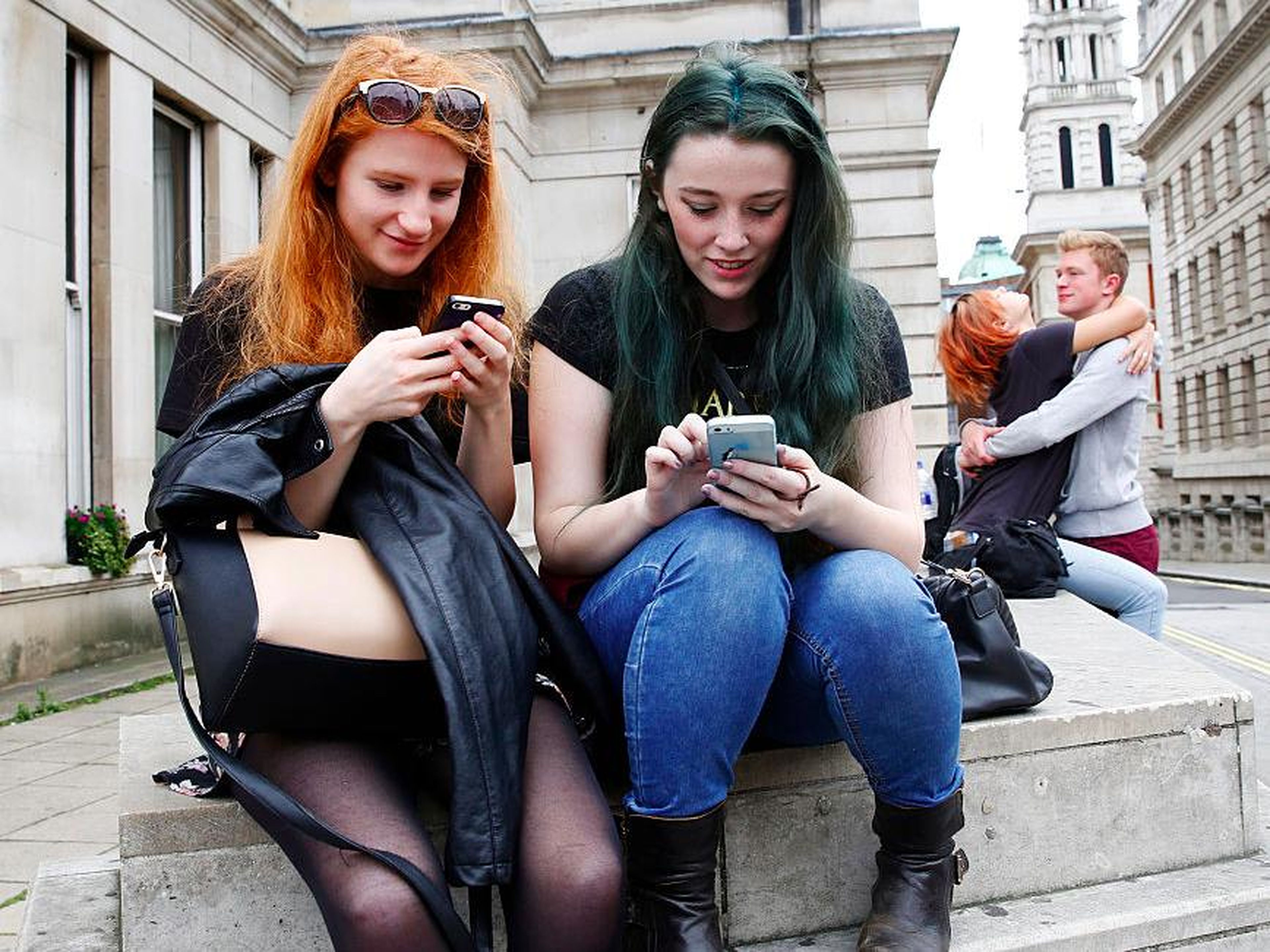 Chicas utilizando el móvil en la calle