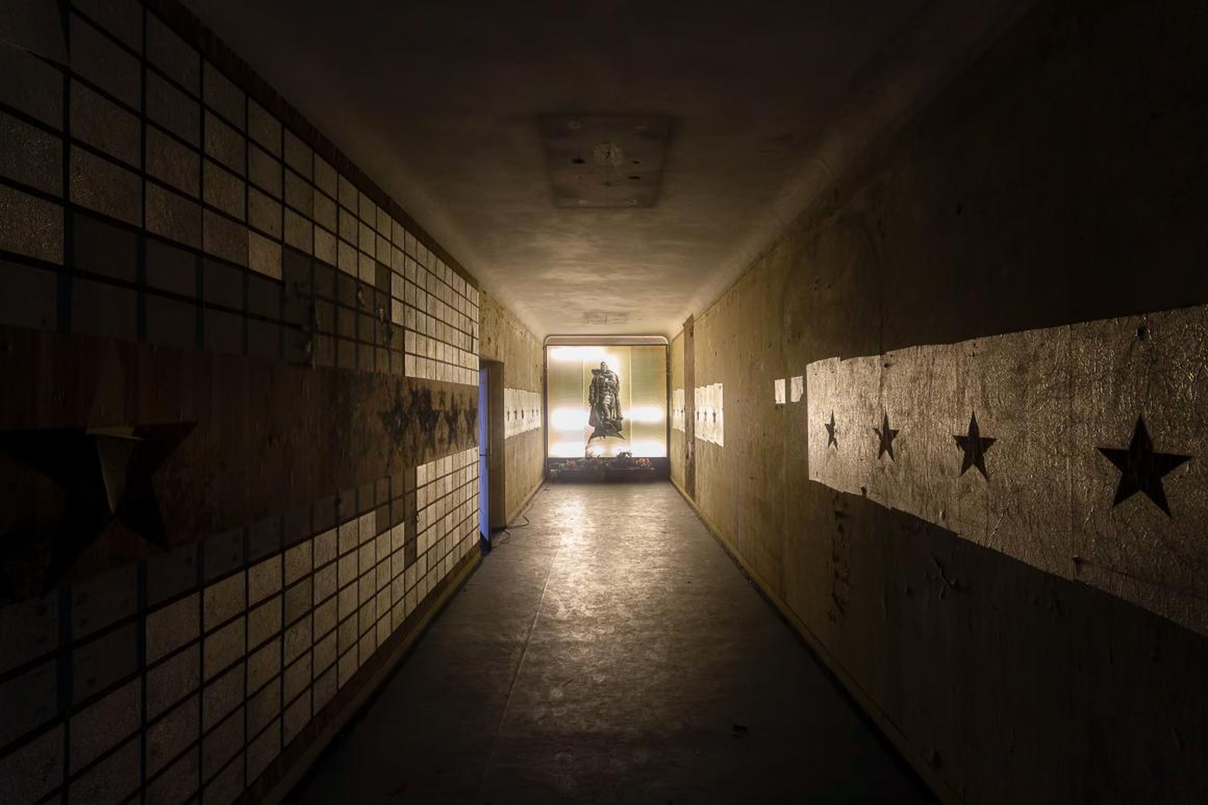 At the end of this dim hallway stands an illuminated image of Joseph Stalin carrying a child.