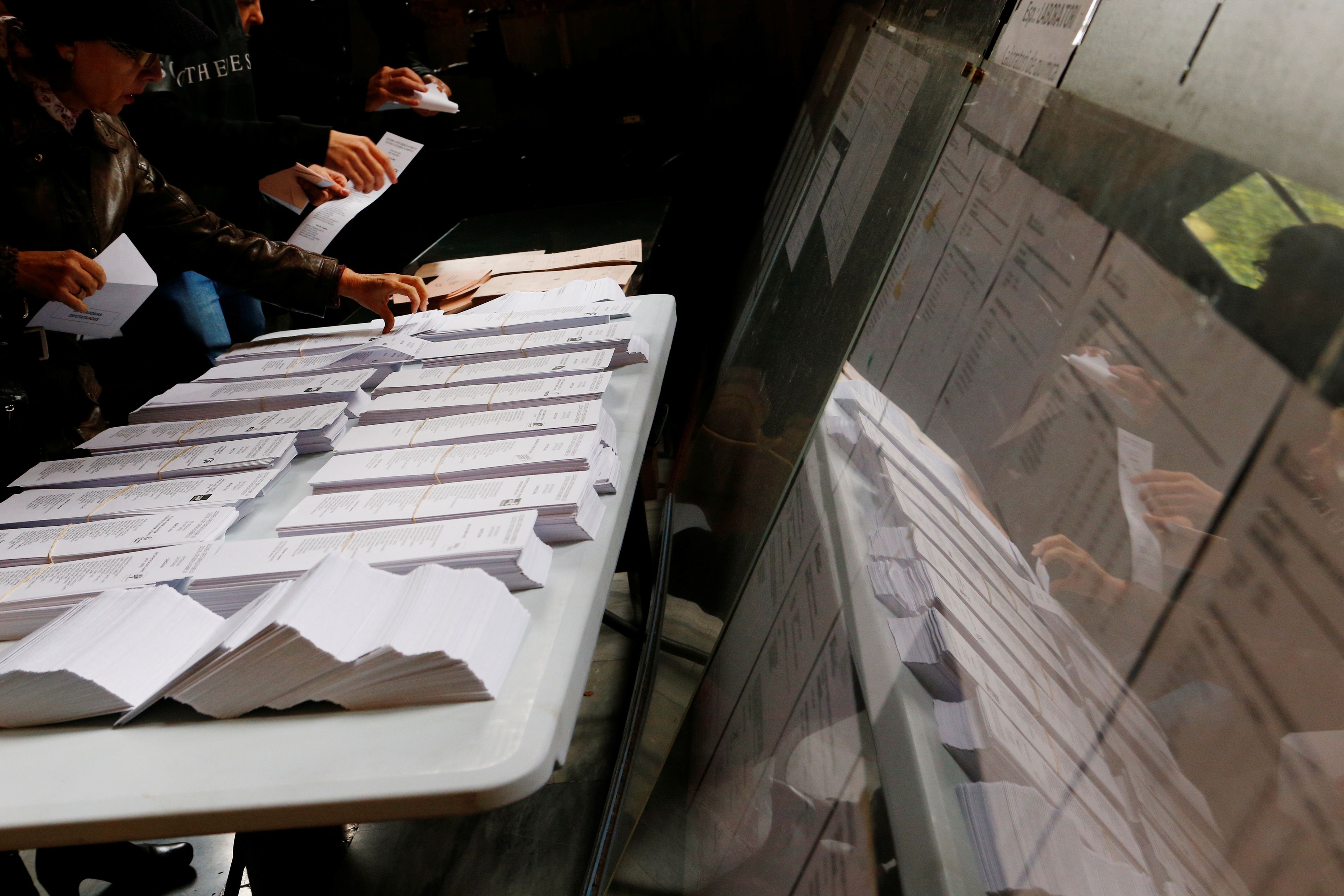 Españoles eligiendo papeletas en las elecciones generales.