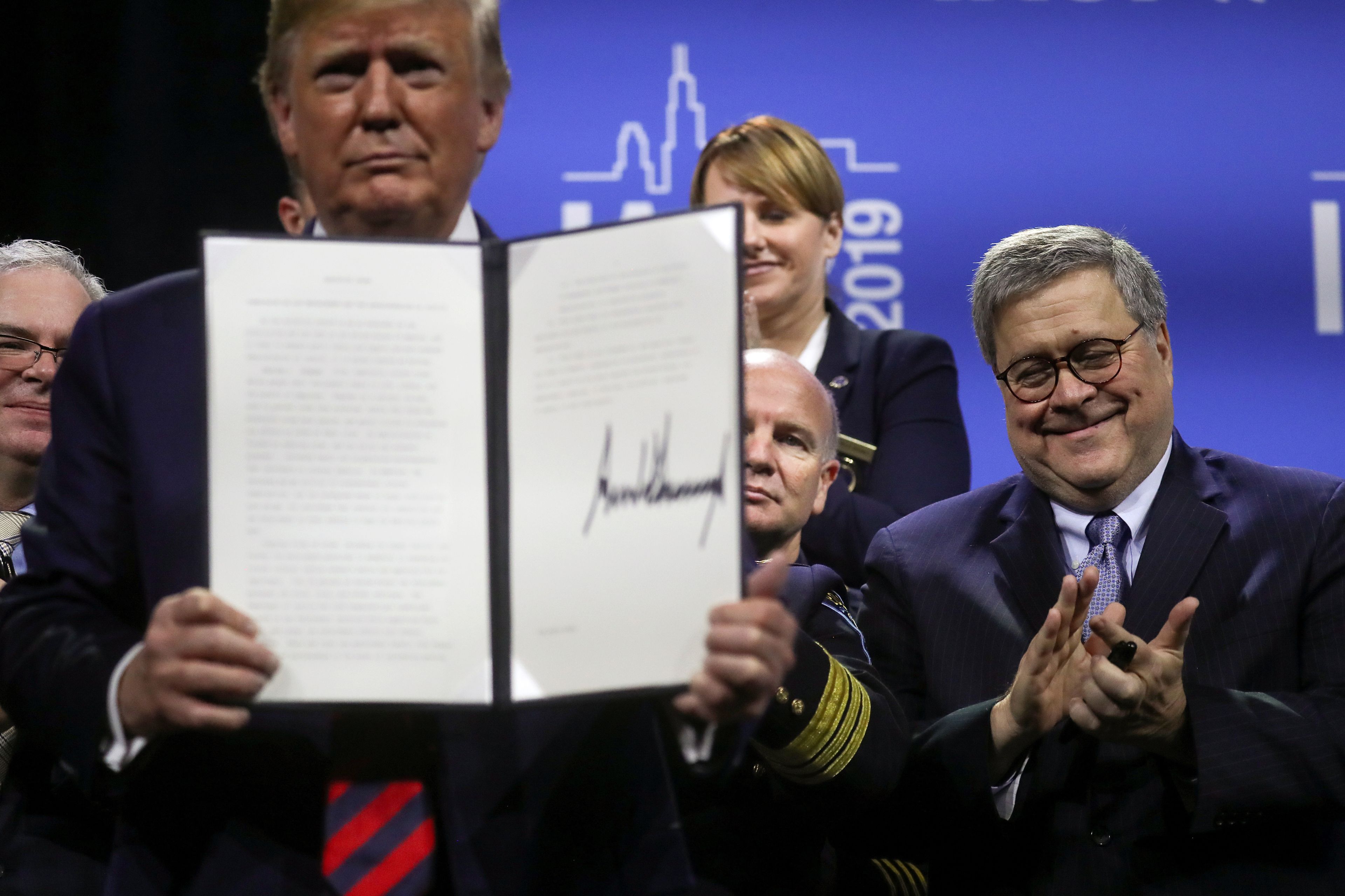 Donald Trump mostrando un documento firmado