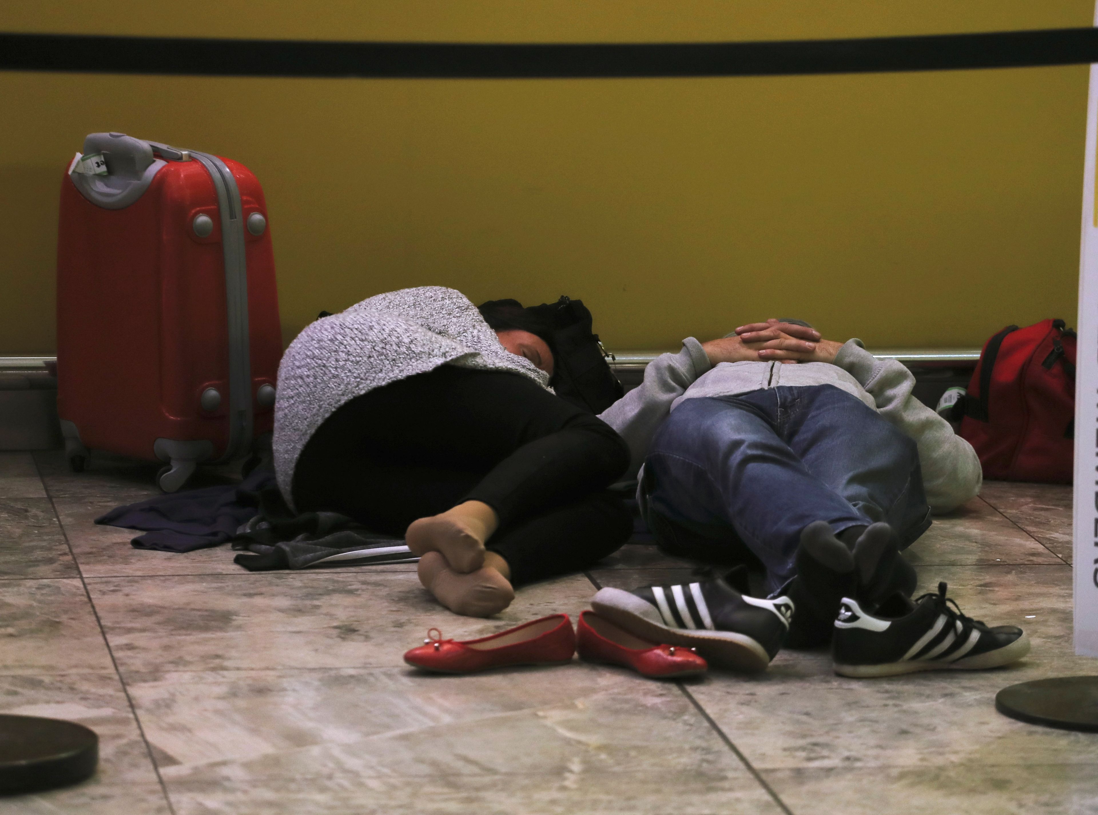 Pasajeros durmiendo en el aeropuerto de Alicante.