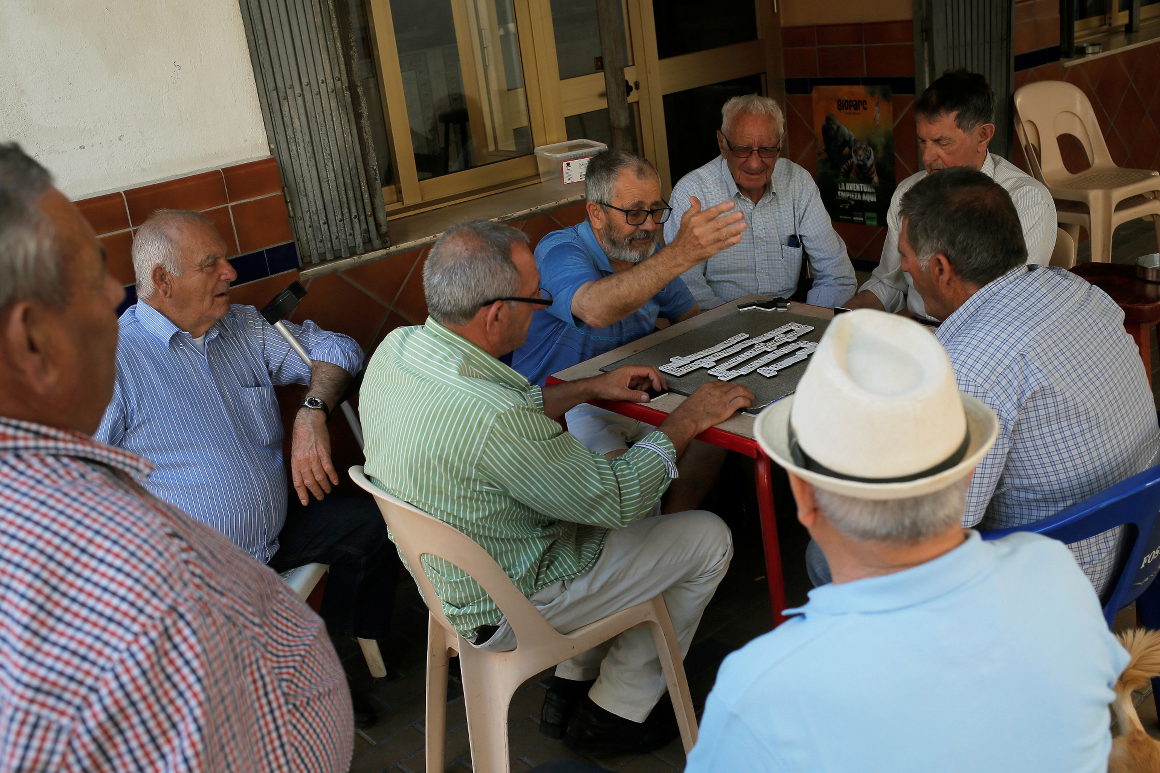 Un grupo de jubilados juega una partida de dominó en una terraza en Fuengirola (Málaga)