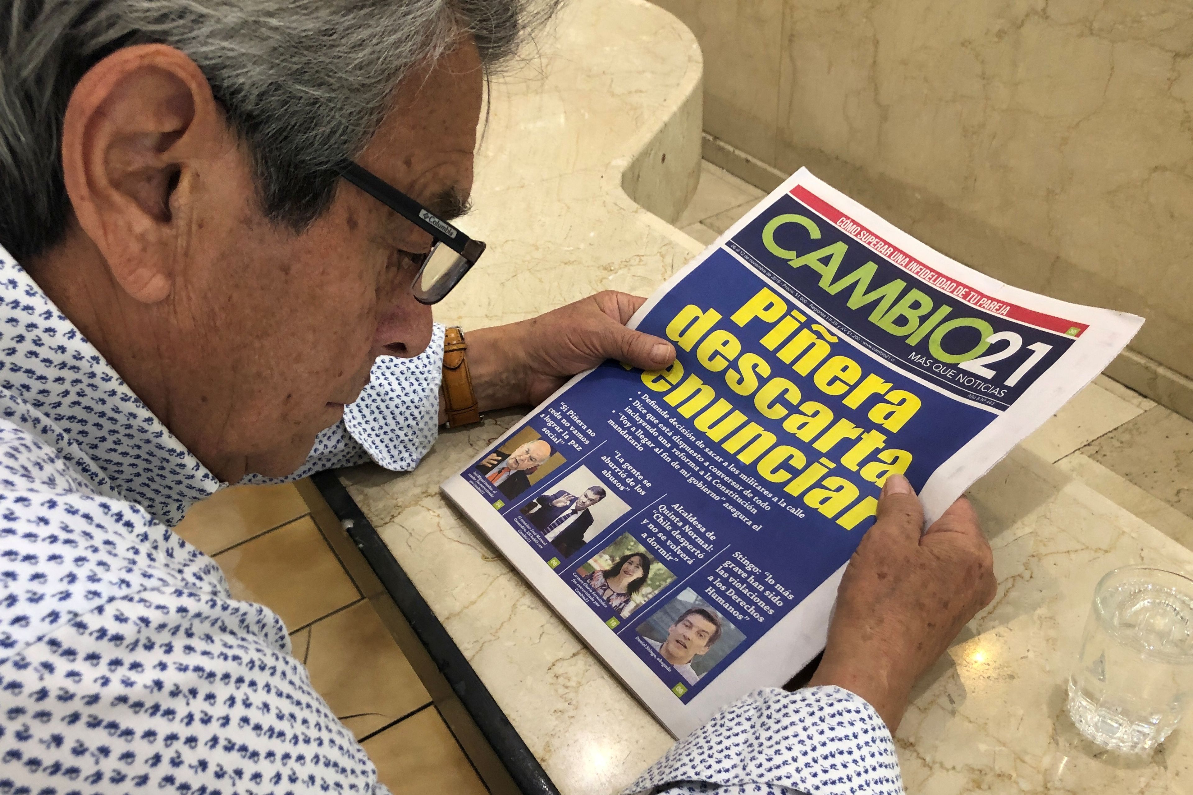 Un hombre lee un periódico sobre las protestas de Chile.
