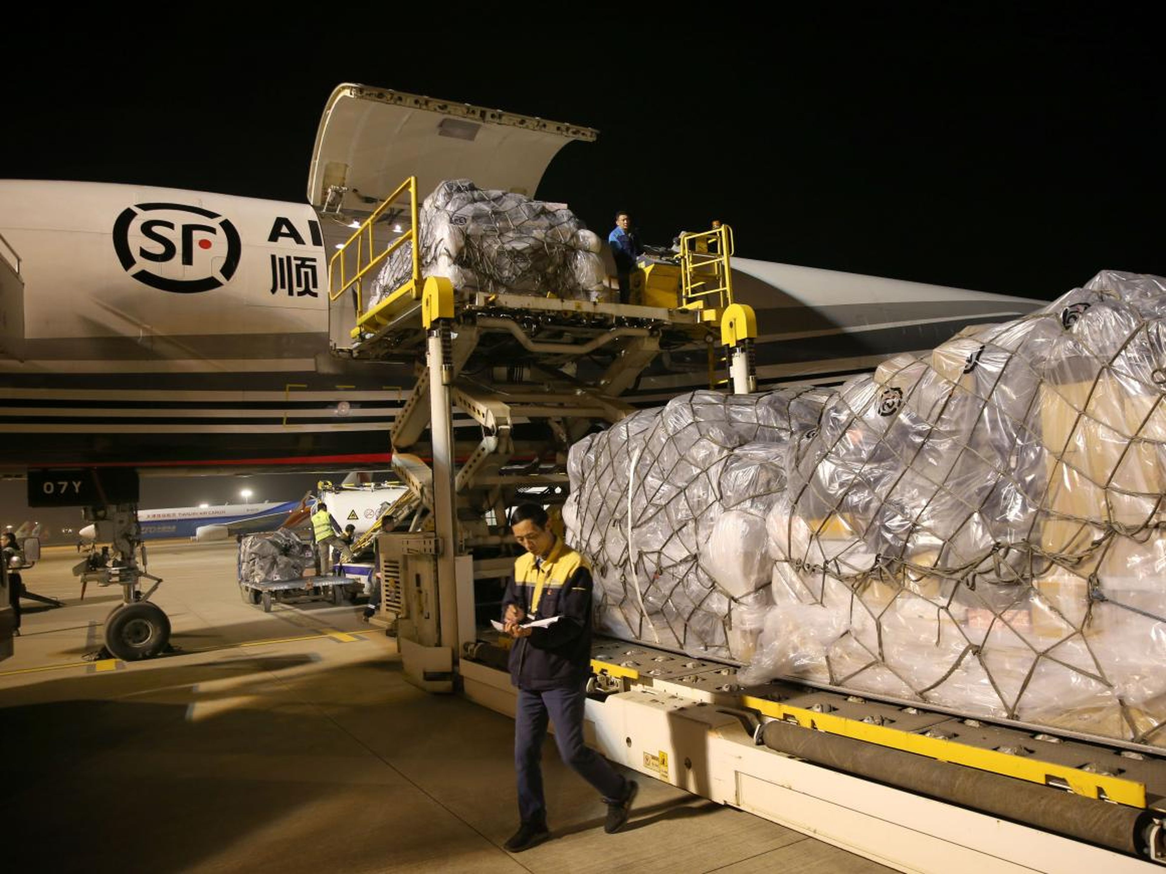 Large amounts of cargo can be seen being loaded into airplanes, like this SF Airlines Boeing 757 aircraft at Nantong Xingdong International Airport.