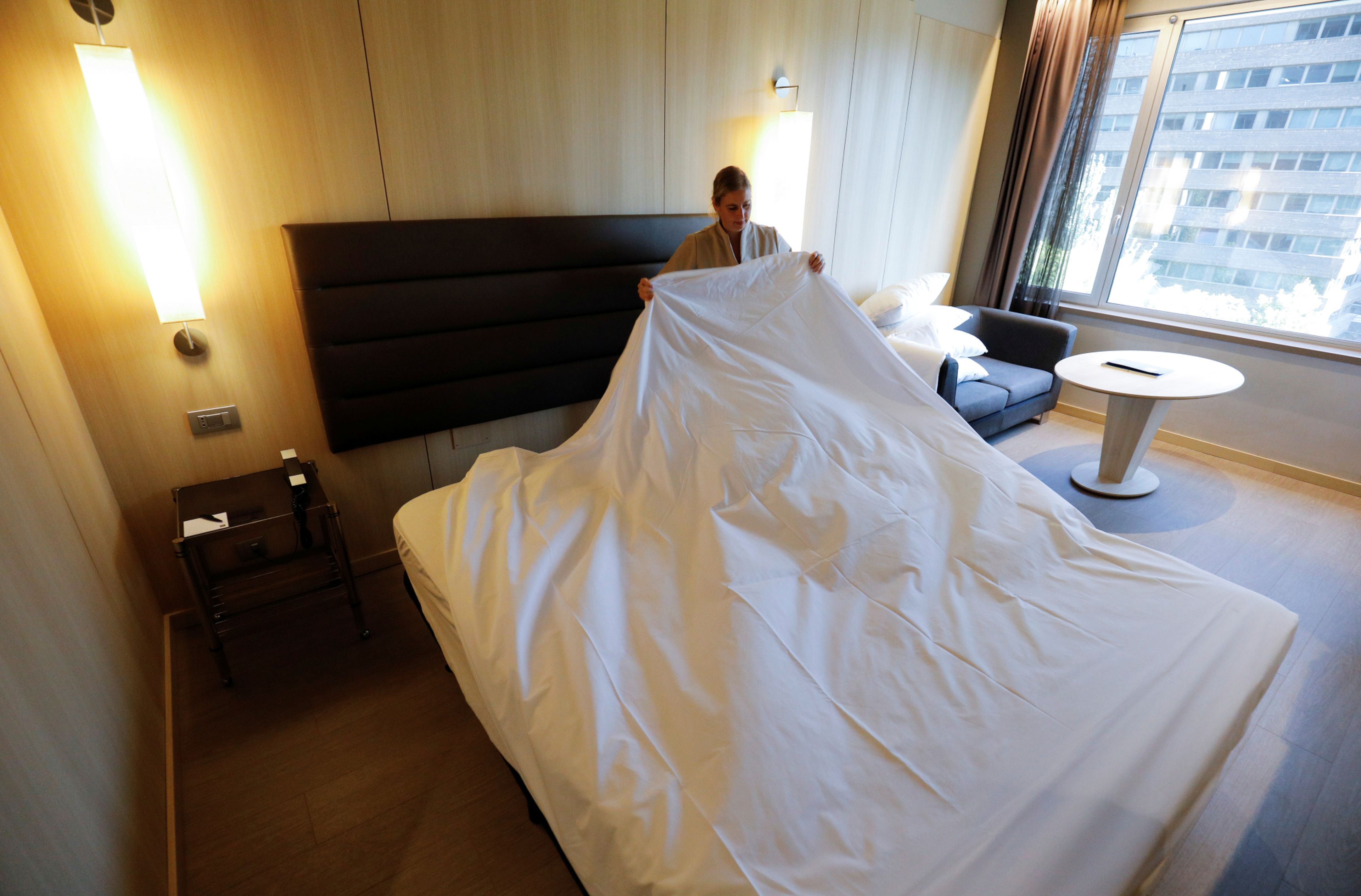 Una limpiadora de un hotel de Madrid hace la cama en una habitación