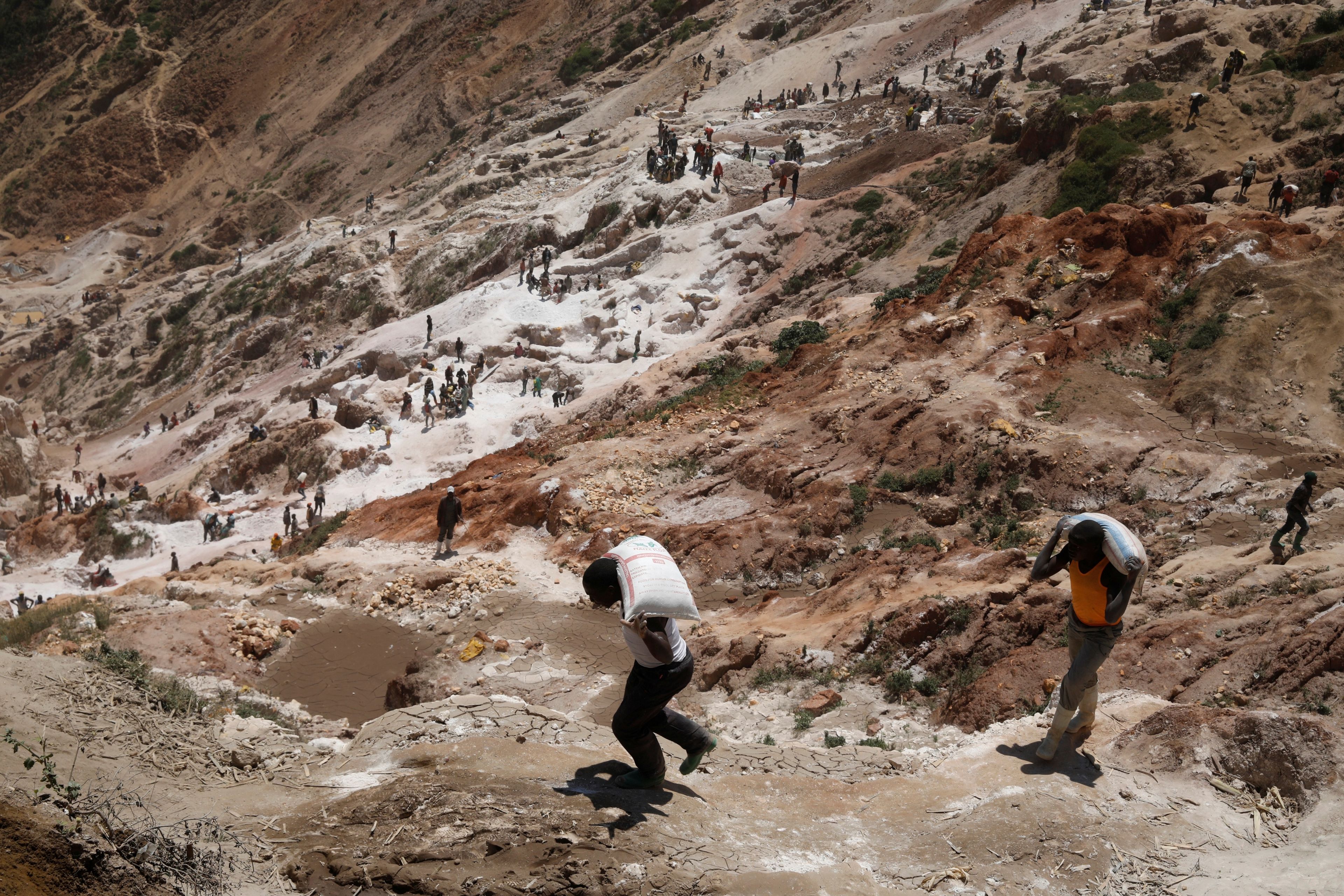 Trabajadores llevan sacos de minerales en la mina de coltán de Rubaya, en la República Democrática del Congo.