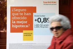 Una mujer pasa ante un anuncio de hipotecas en una sucursal bancaria