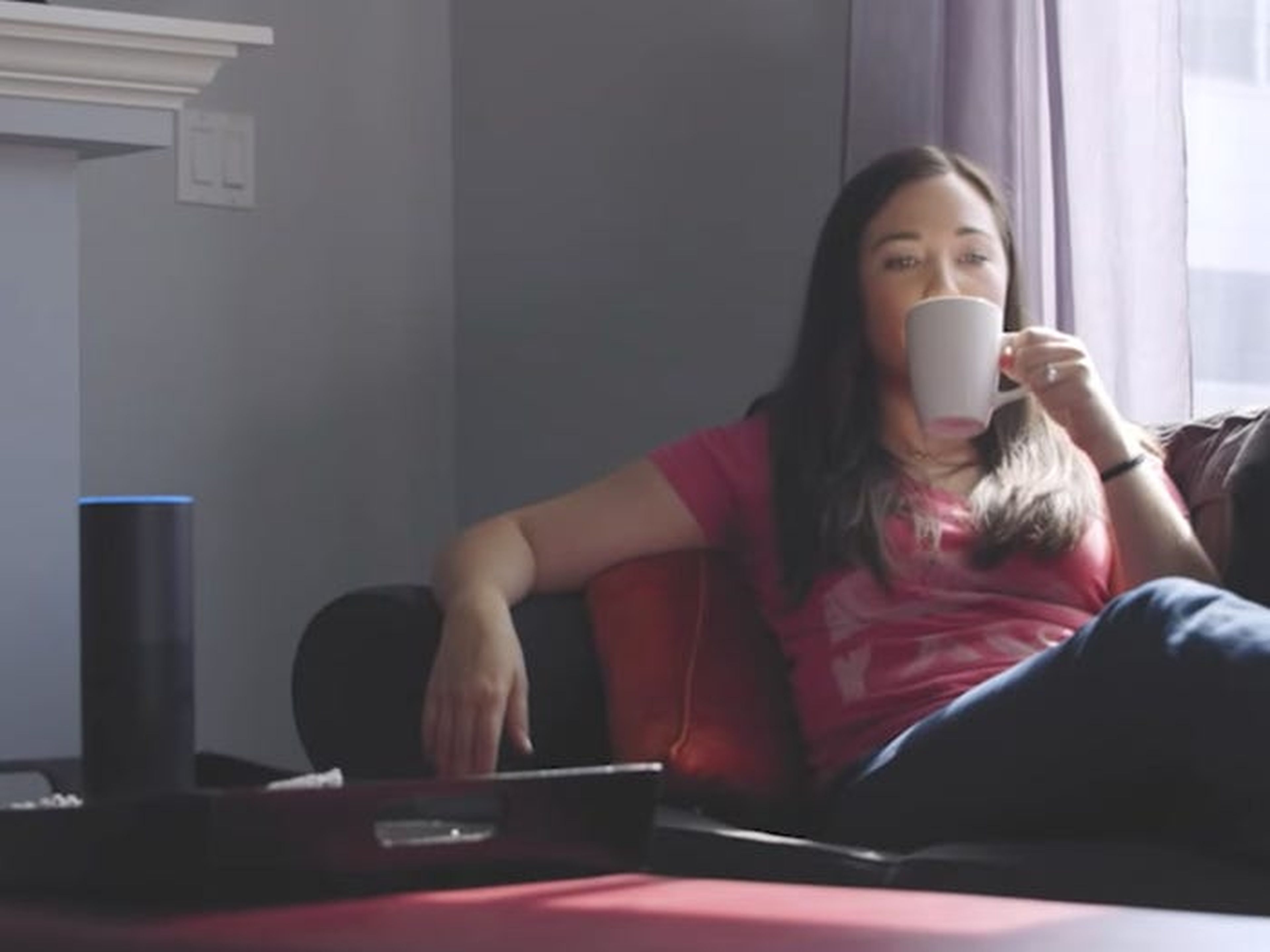 Mujer tomando té junto a Amazon Echo.