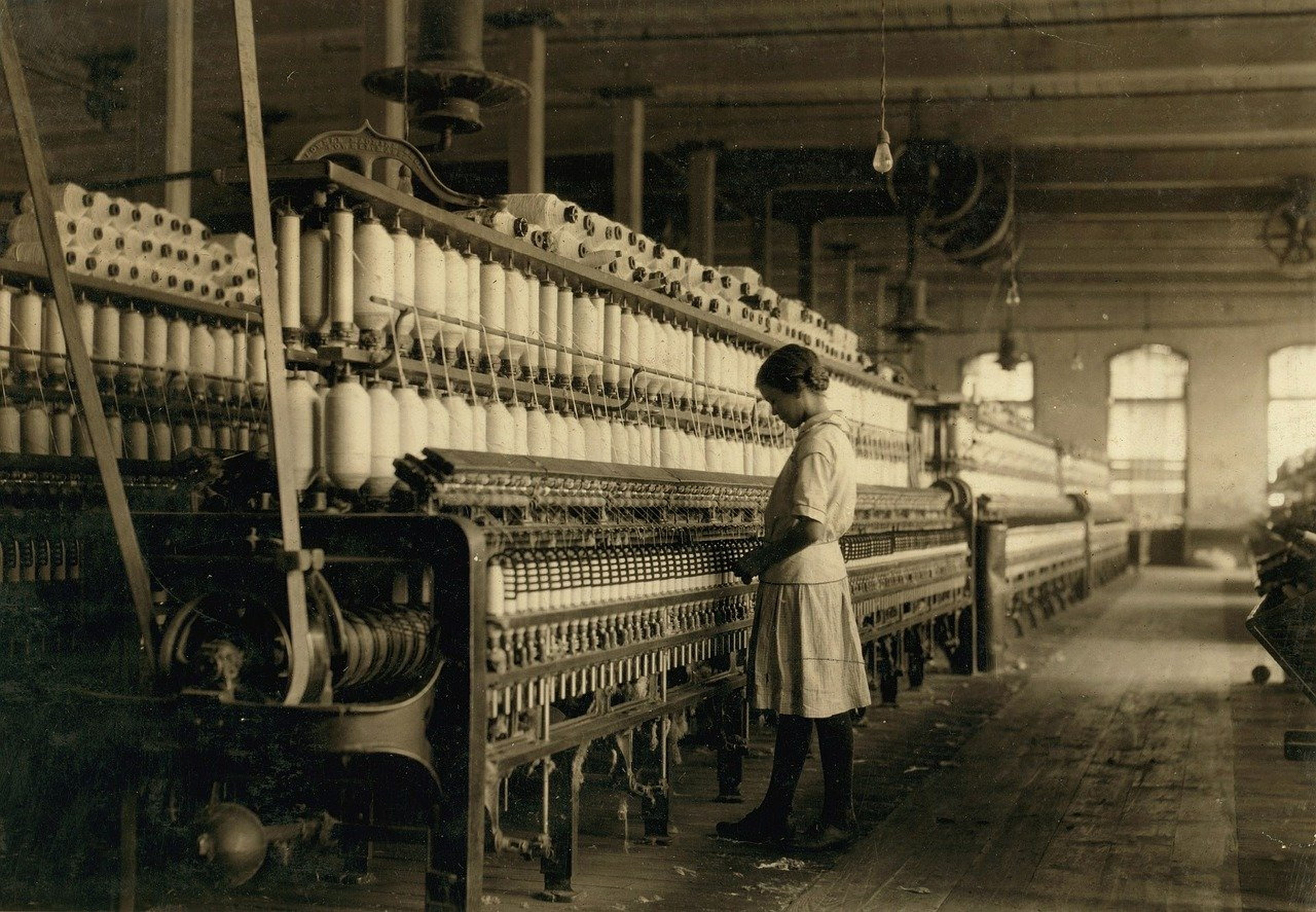 Una niña trabaja en una fábrica textil a principios del siglo XX
