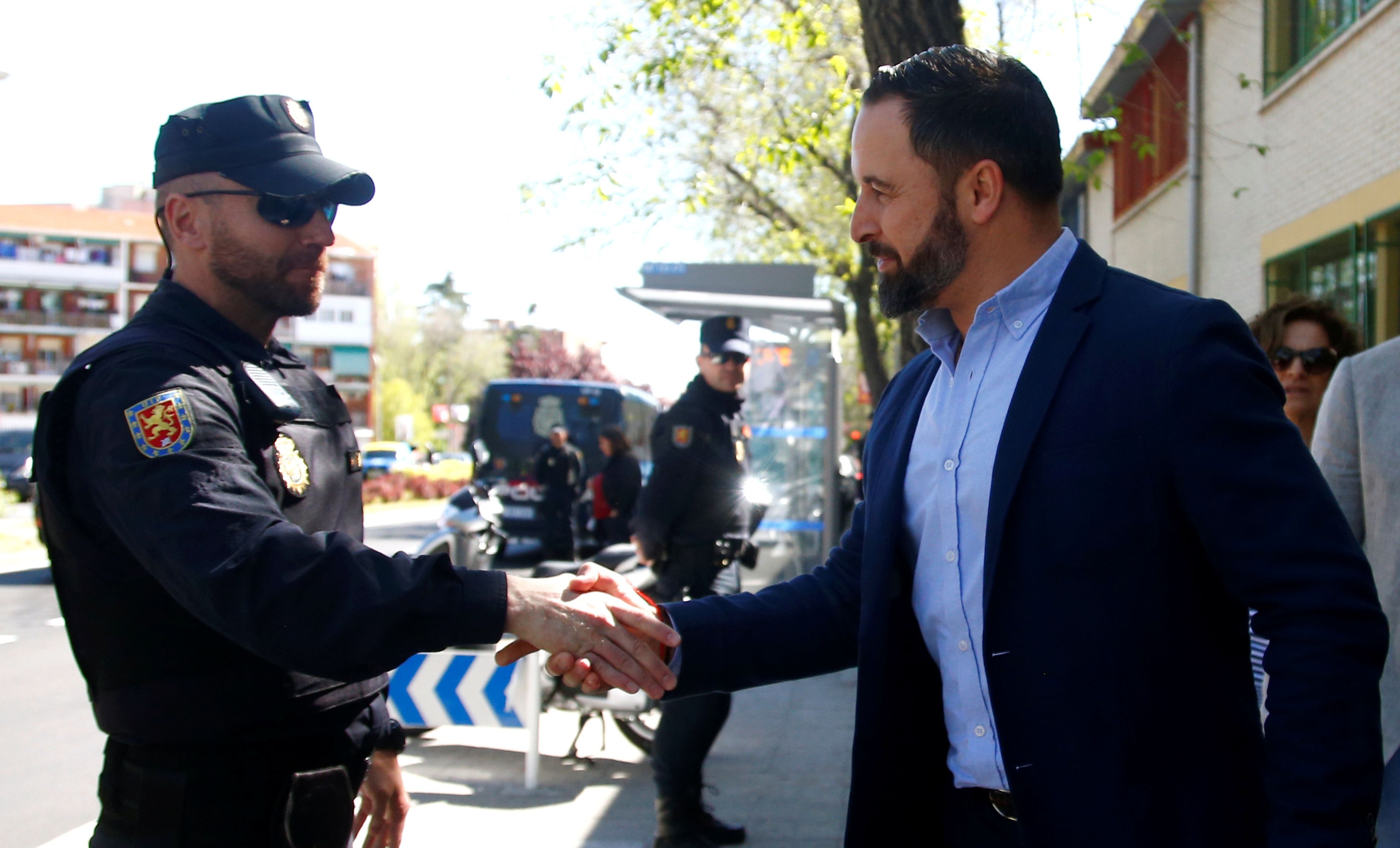 Santiago abascal (vox) dando la mano a un policía.