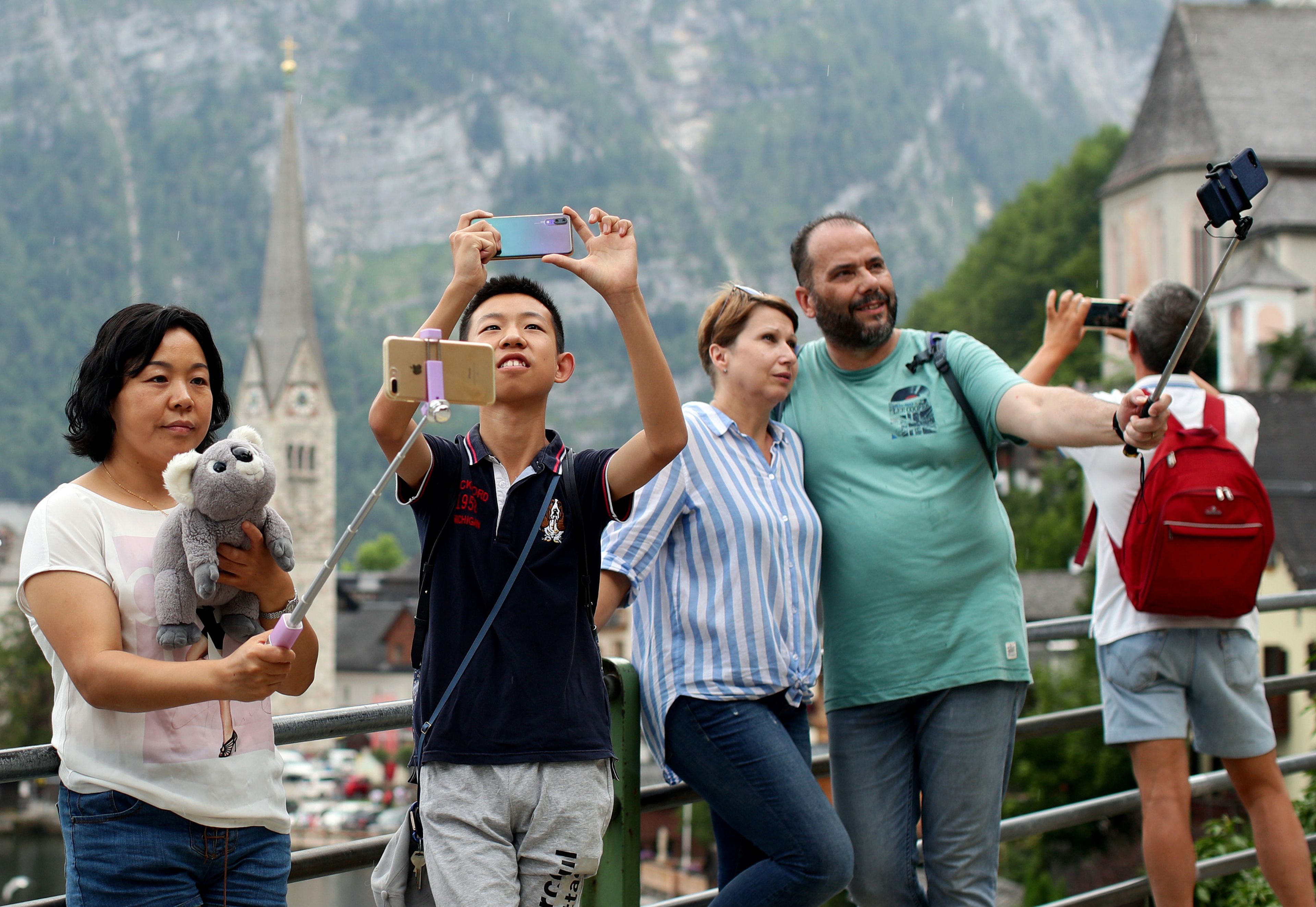 Turistas utilizando sus smartphones para retratarse y hacerse selfies.