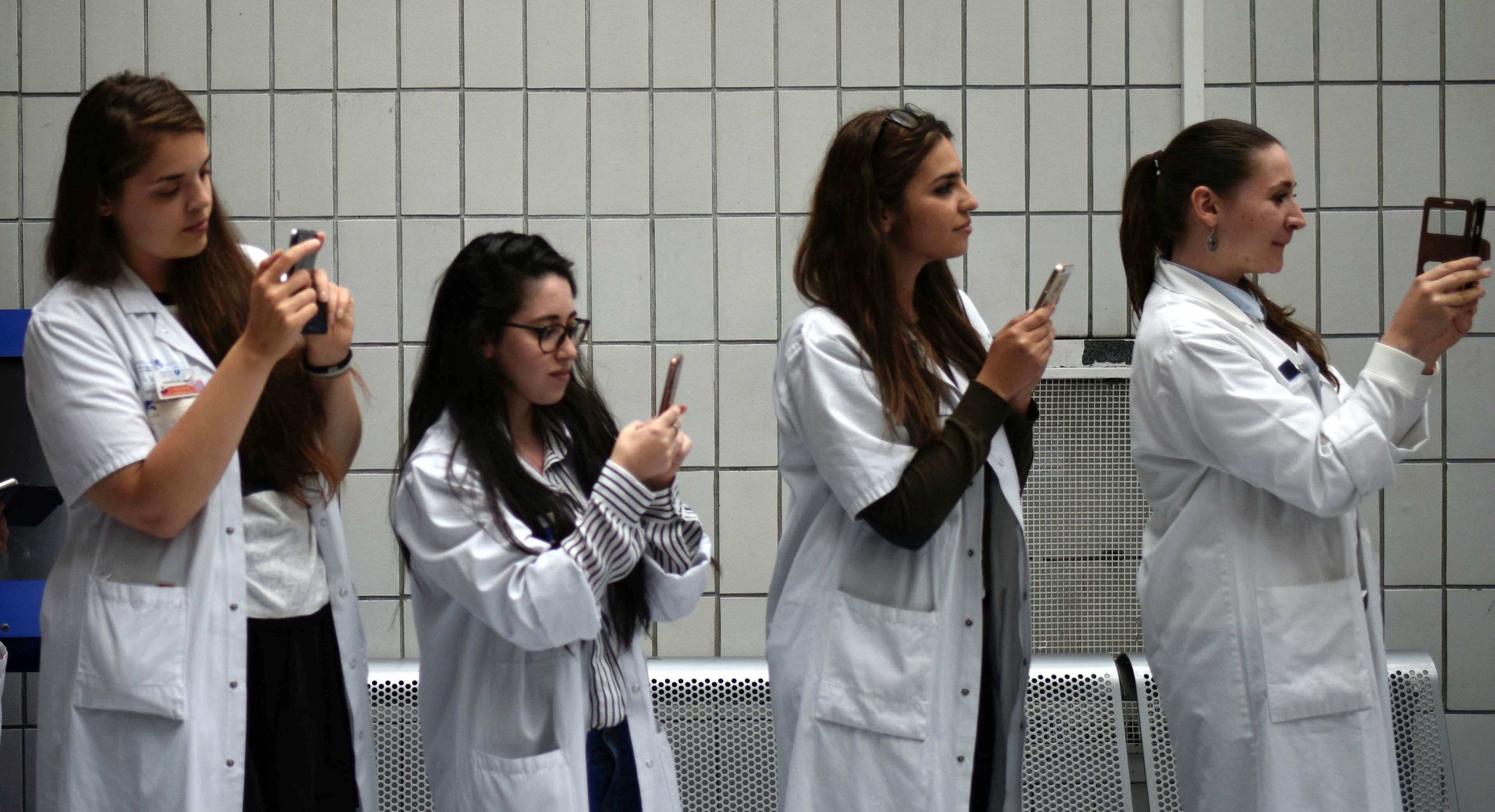 Unas médicos con smartphones haciendo fotos.
