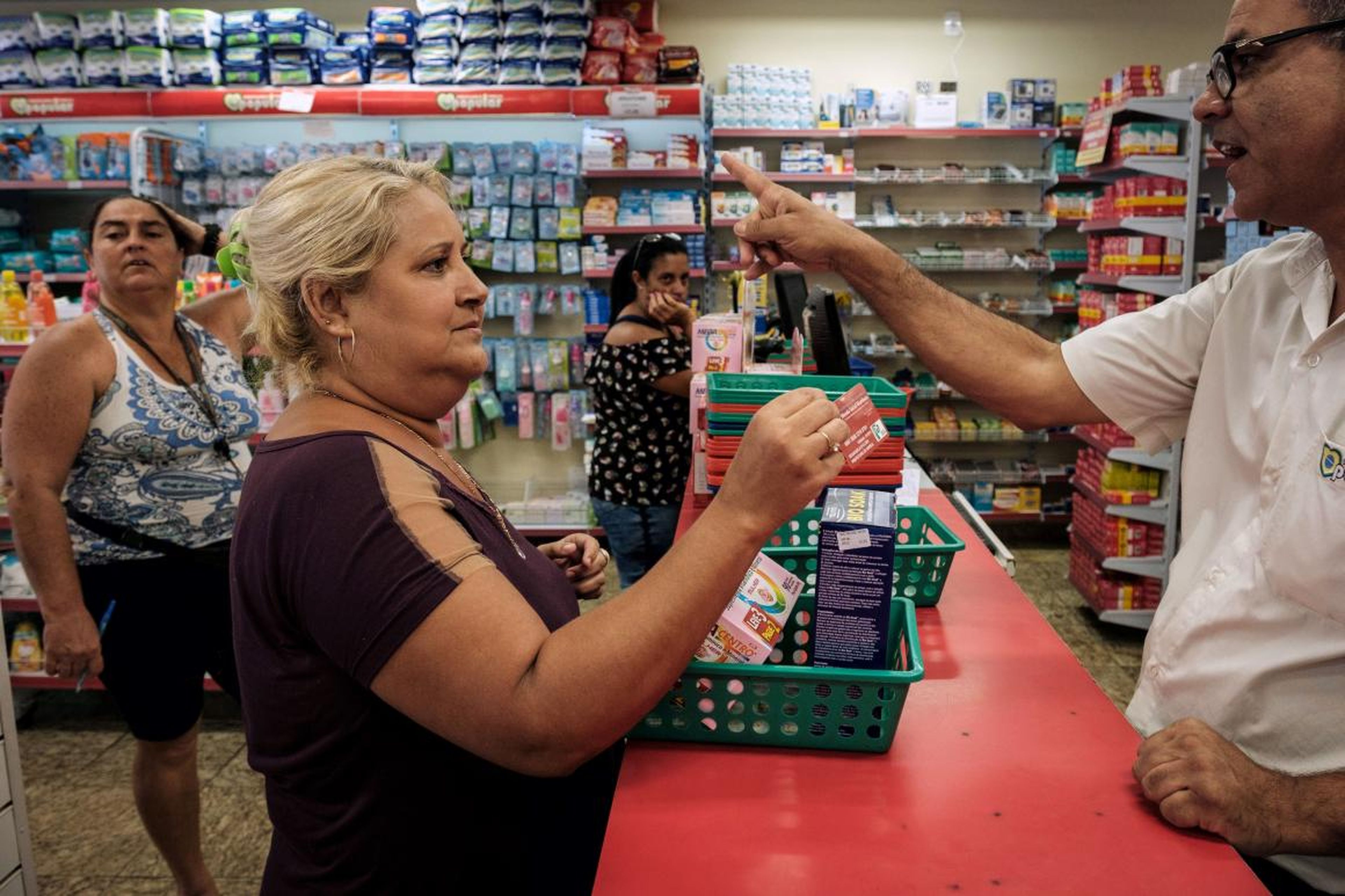 A woman using her "Mumbuca" basic-income card at a pharmacy in Marica, Brazil.