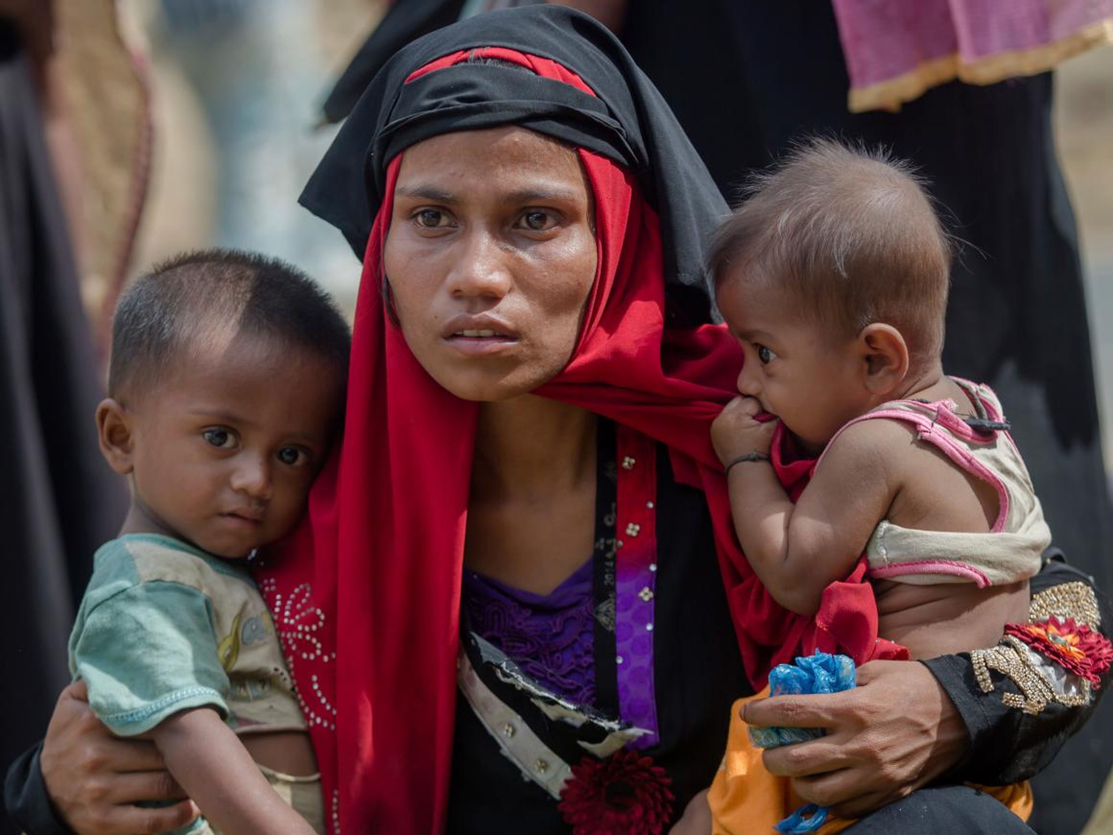FILE - In this Oct. 22, 2017, file photo, Rohingya Muslim woman, Rukaya Begum, who crossed over from Myanmar into Bangladesh, holds her children after the government moved them to newly allocated refugee camp areas, near Kutupalong, Bangladesh. (AP Photo