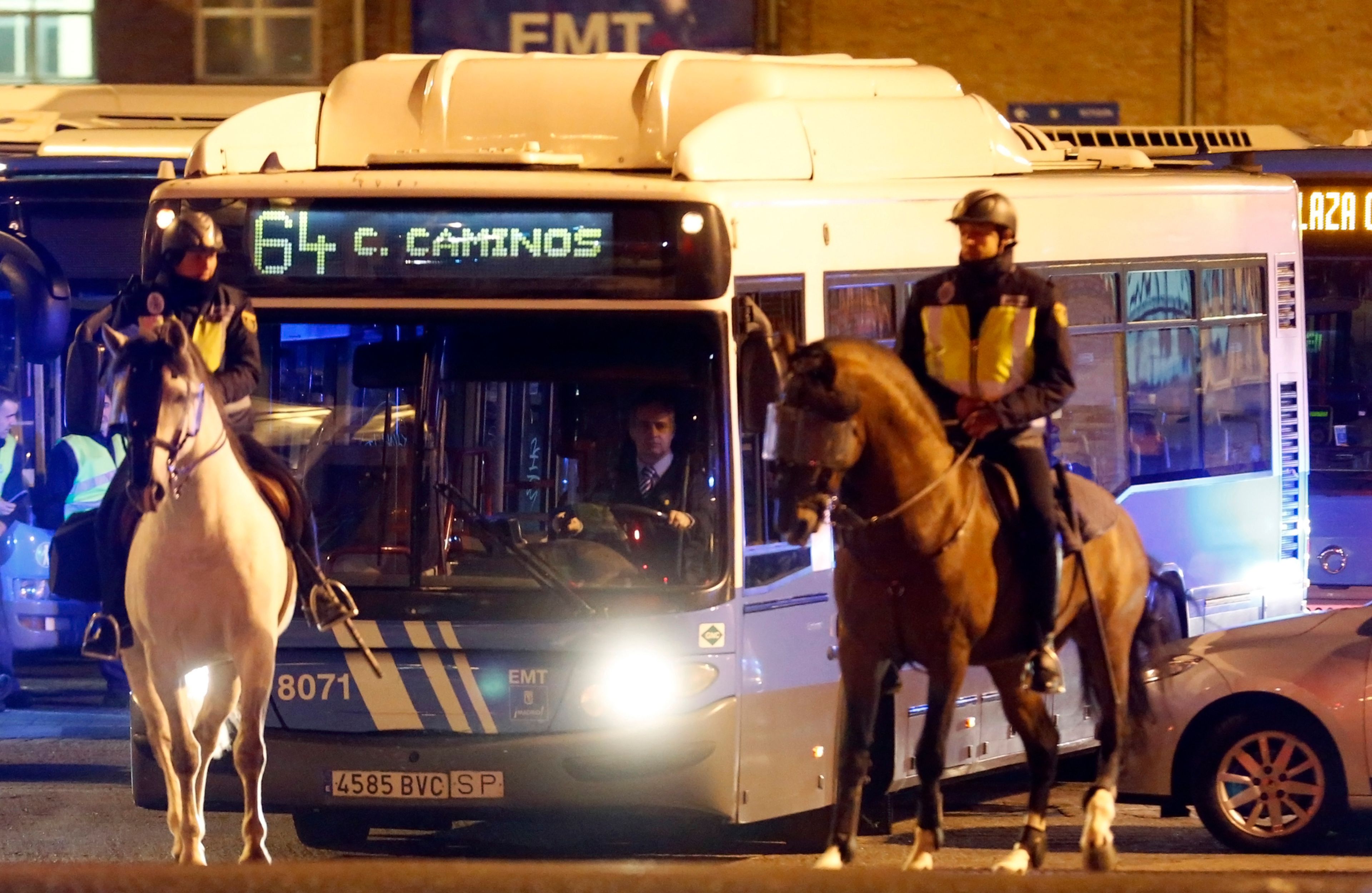 Agentes de policía a caballo escoltan a un autobús de la EMT durante la huelga general de 2012