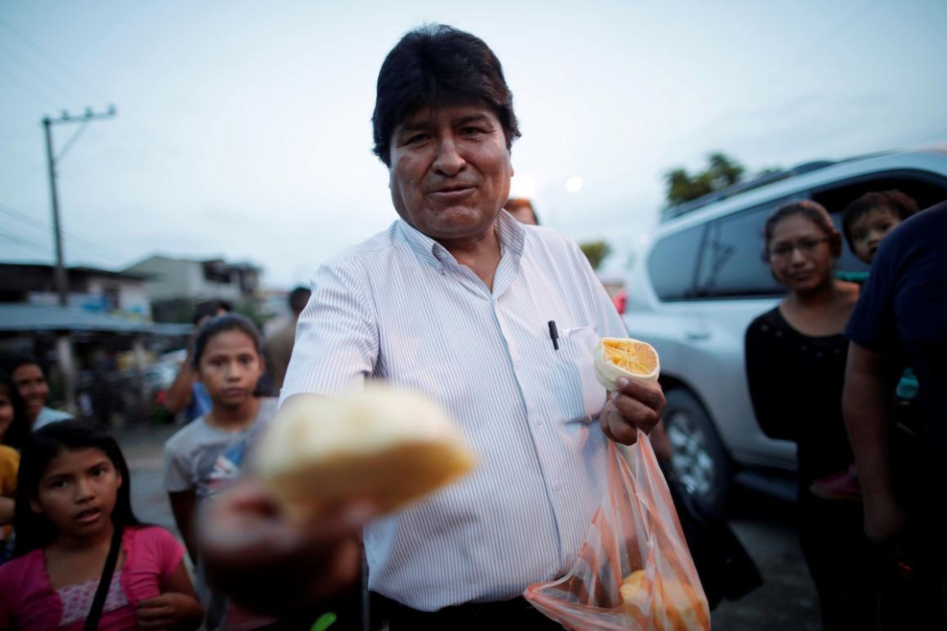 El ex presidente de Bolivia y ex candidato presidencial del Movimiento al Socialismo (MAS), Evo Morales, ofrece frutas a los pobres en una calle de Shinahota, Bolivia, el 19 de octubre.