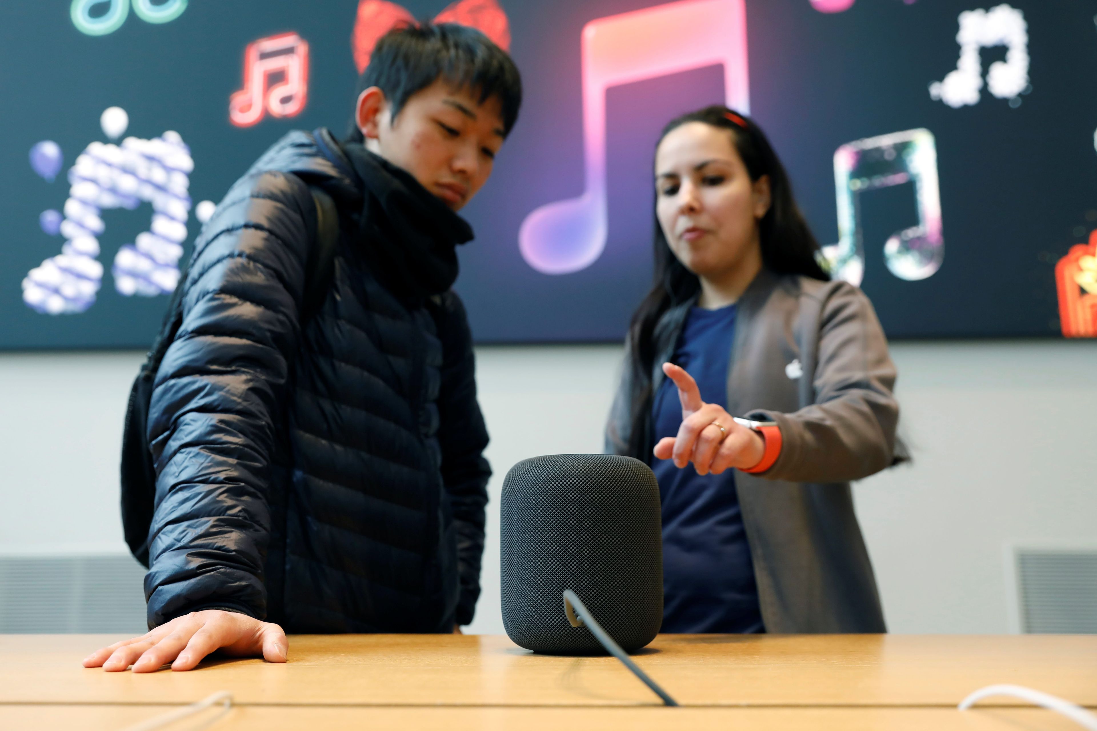 Dos jóvenes probado el HomePod de Apple.