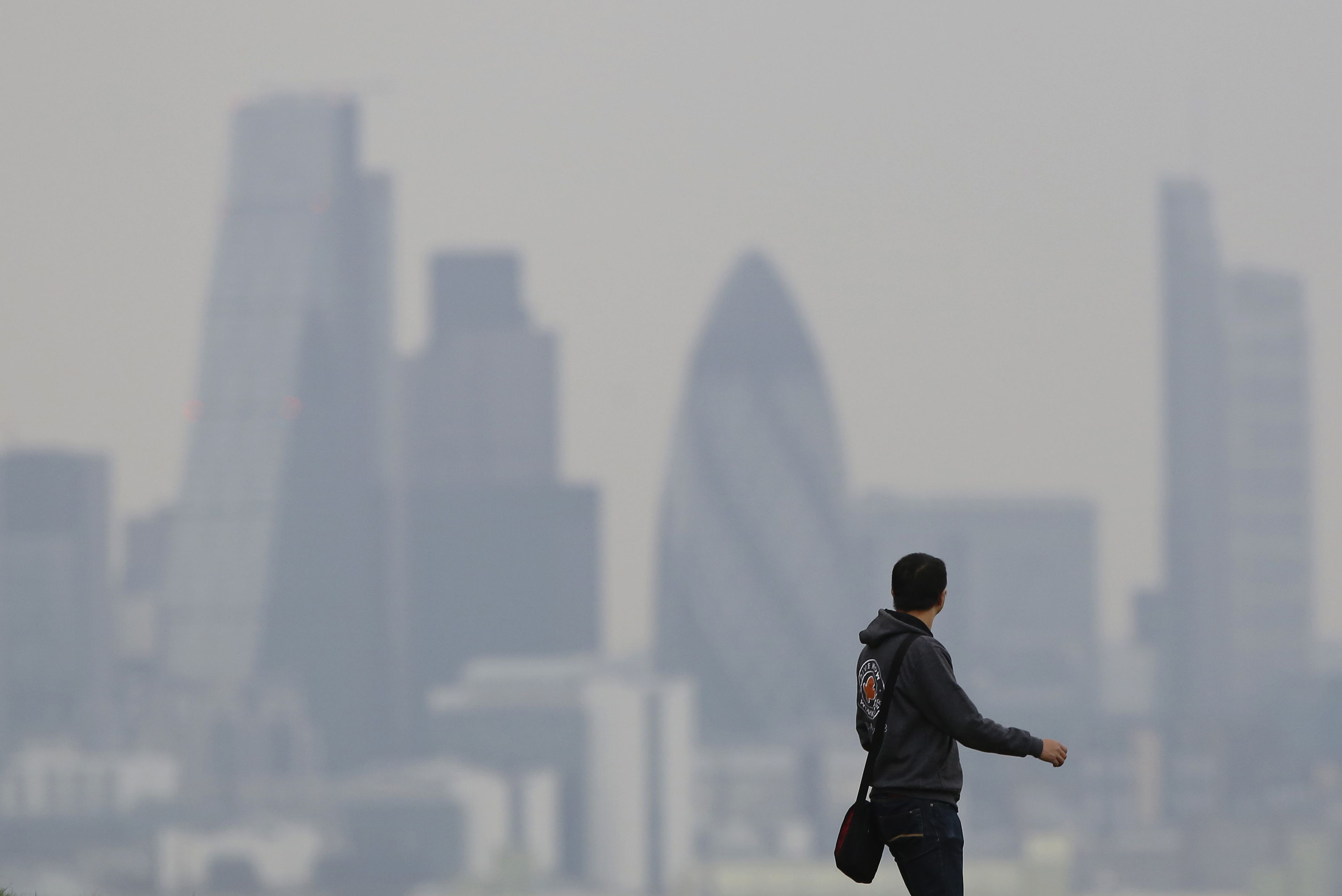 Un turista pasea con el skyline de Londres de fondo durante un fuerte episodio de contaminación en la capital británica.