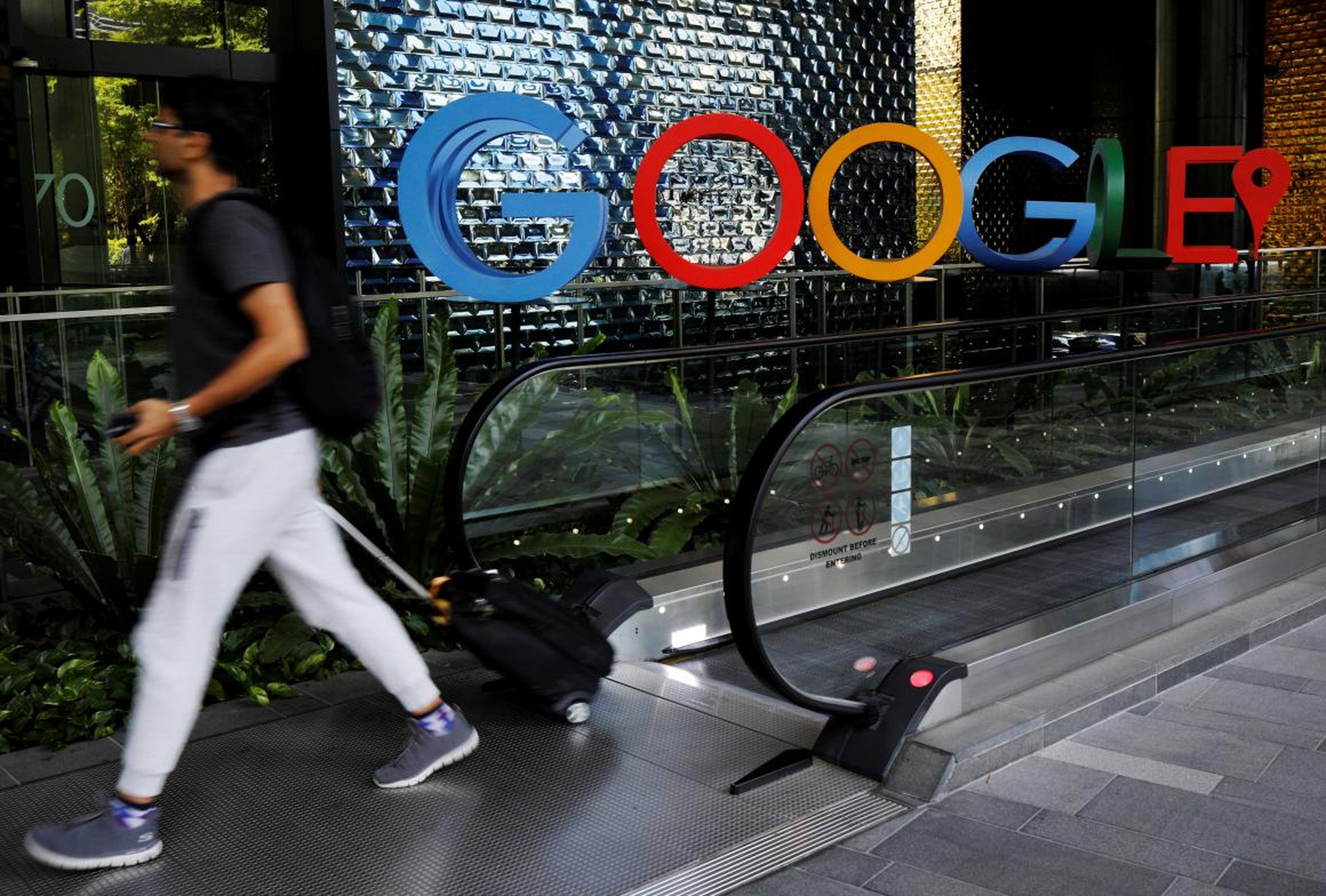 FOTOS DE ARCHIVO: Un hombre pasa por un cartel de Google fuera de su oficina en Singapur.