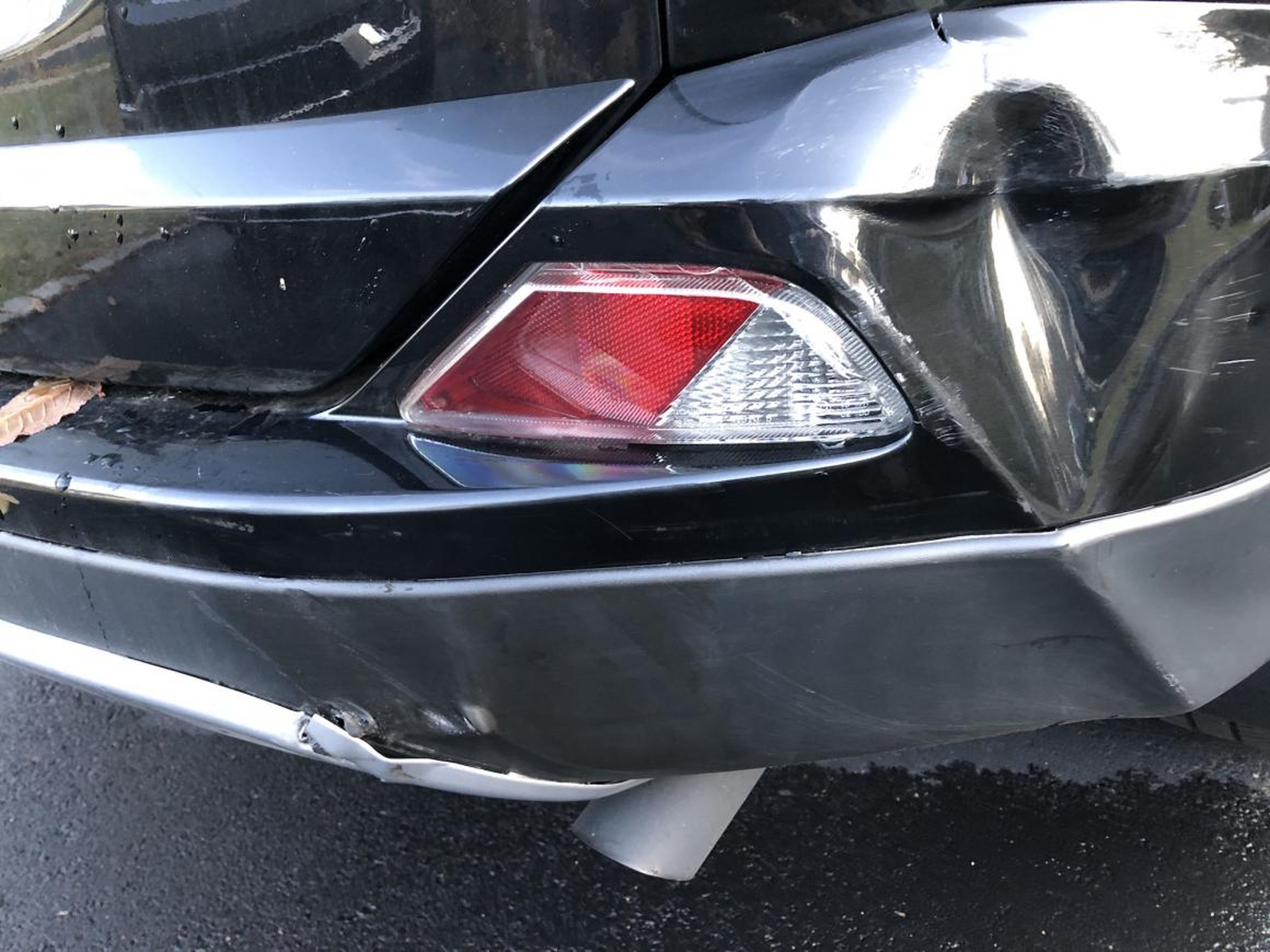 This isn't going to be a serious repair — just enough to hold by bumper together for a few months. I also have to deal with that damage to the trim down by the exhaust pipe. And I'm not going to worry about that dent.
