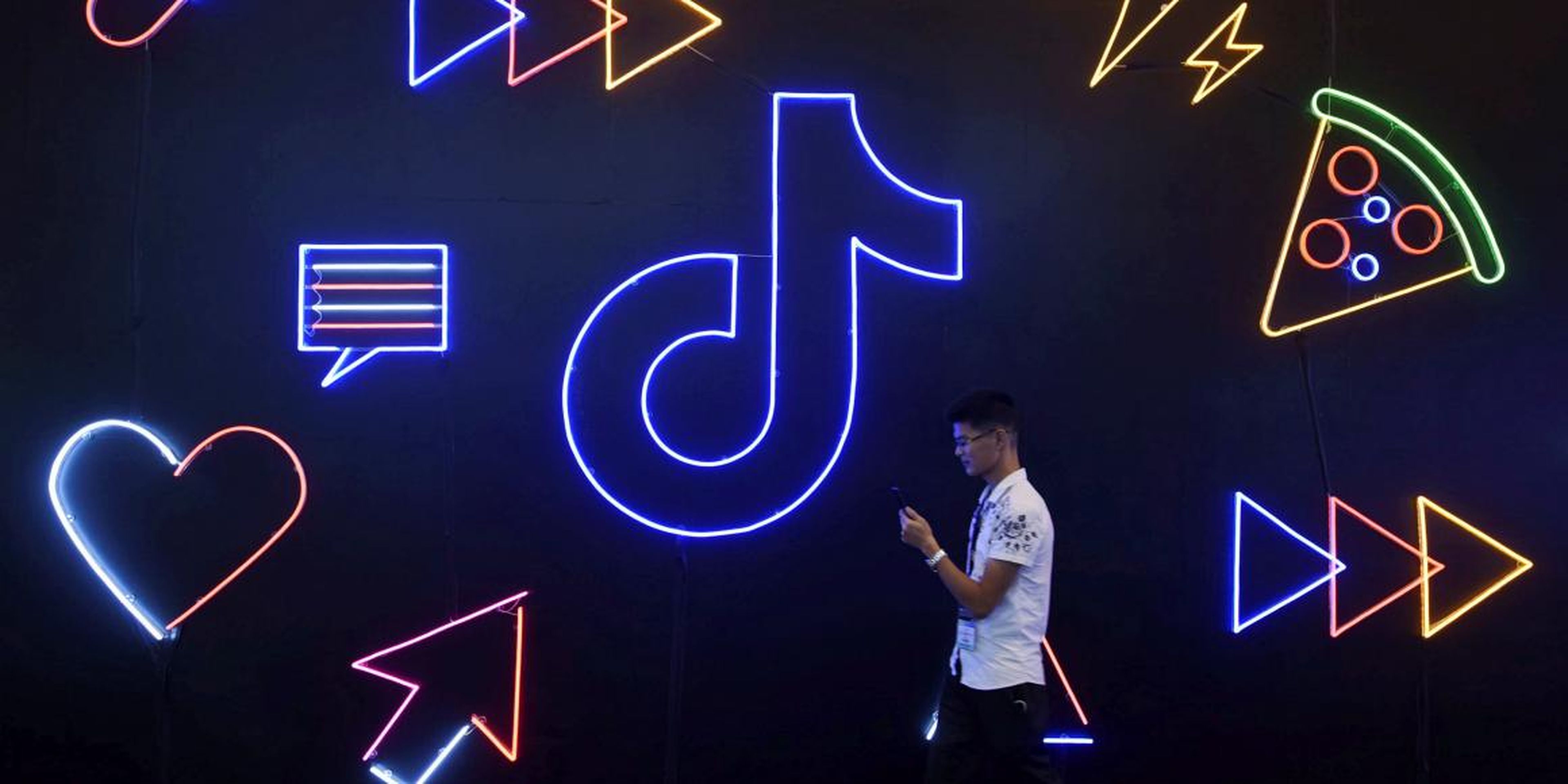 Un hombre pasa junto a un letrero de TikTok en la Exposición Internacional de Productos Artificiales en Hangzhou, China, en octubre de 2019.