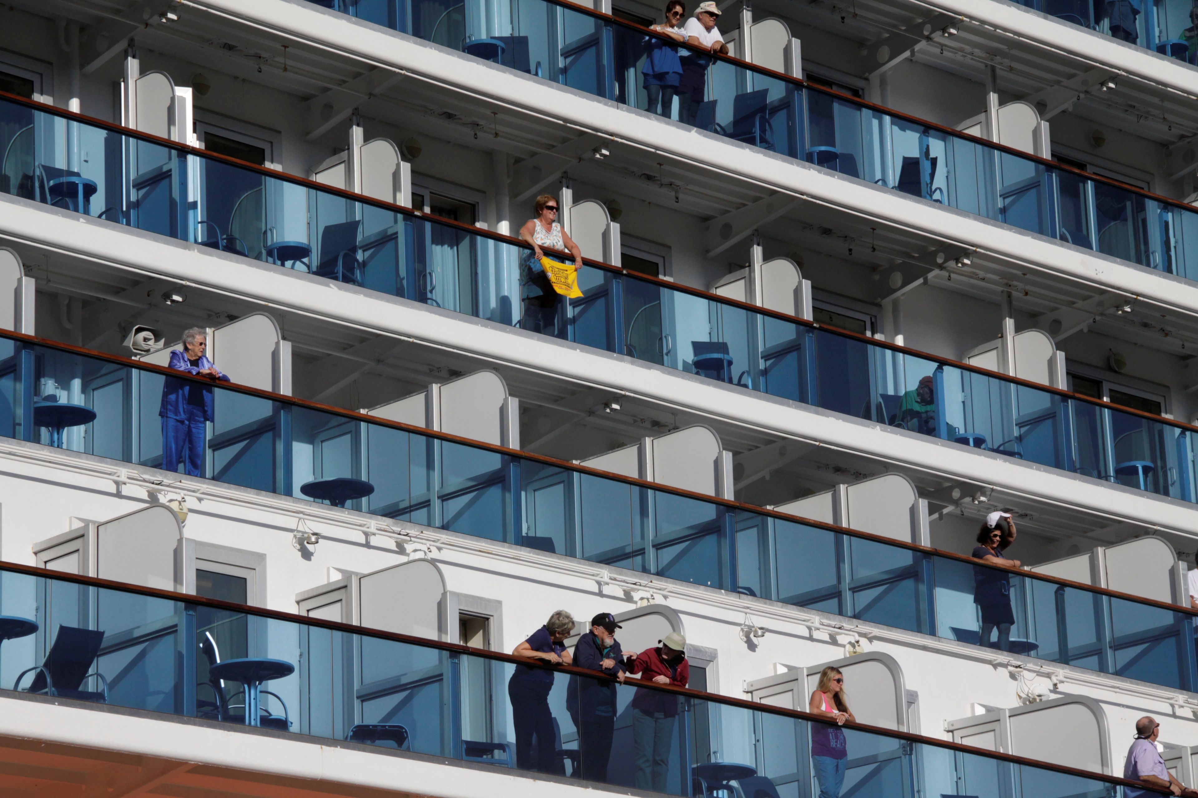 Pasajeros en los balcones de los camarotes de un crucero.