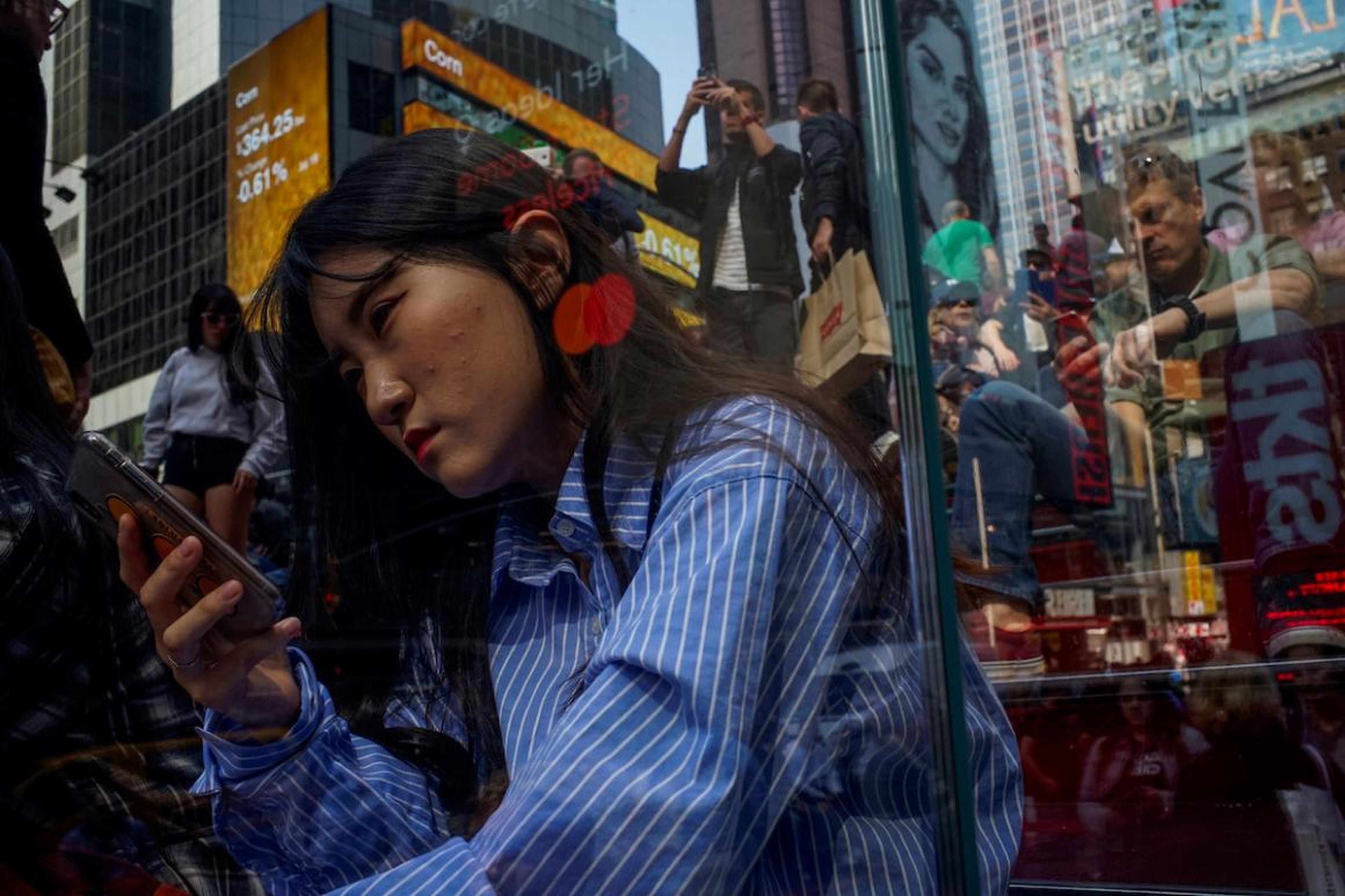 La gente mira sus móviles en Times Square en la ciudad de Nueva York el 8 de mayo.