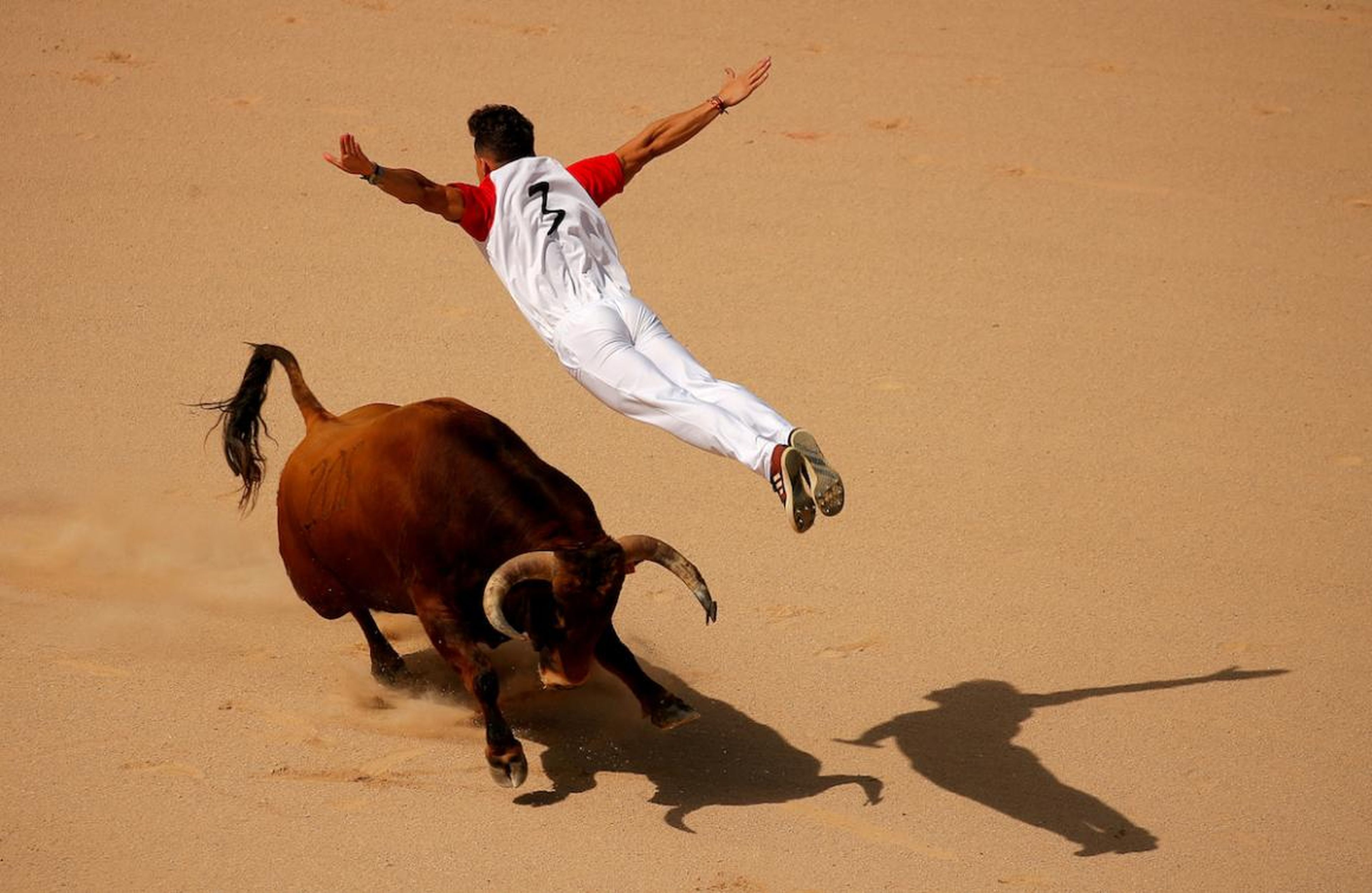 Un recortador salta sobre un toro durante un concurso en la plaza de toros Monumetal de Pamplona durante las fiestas de San Fermín, el 13 de julio.