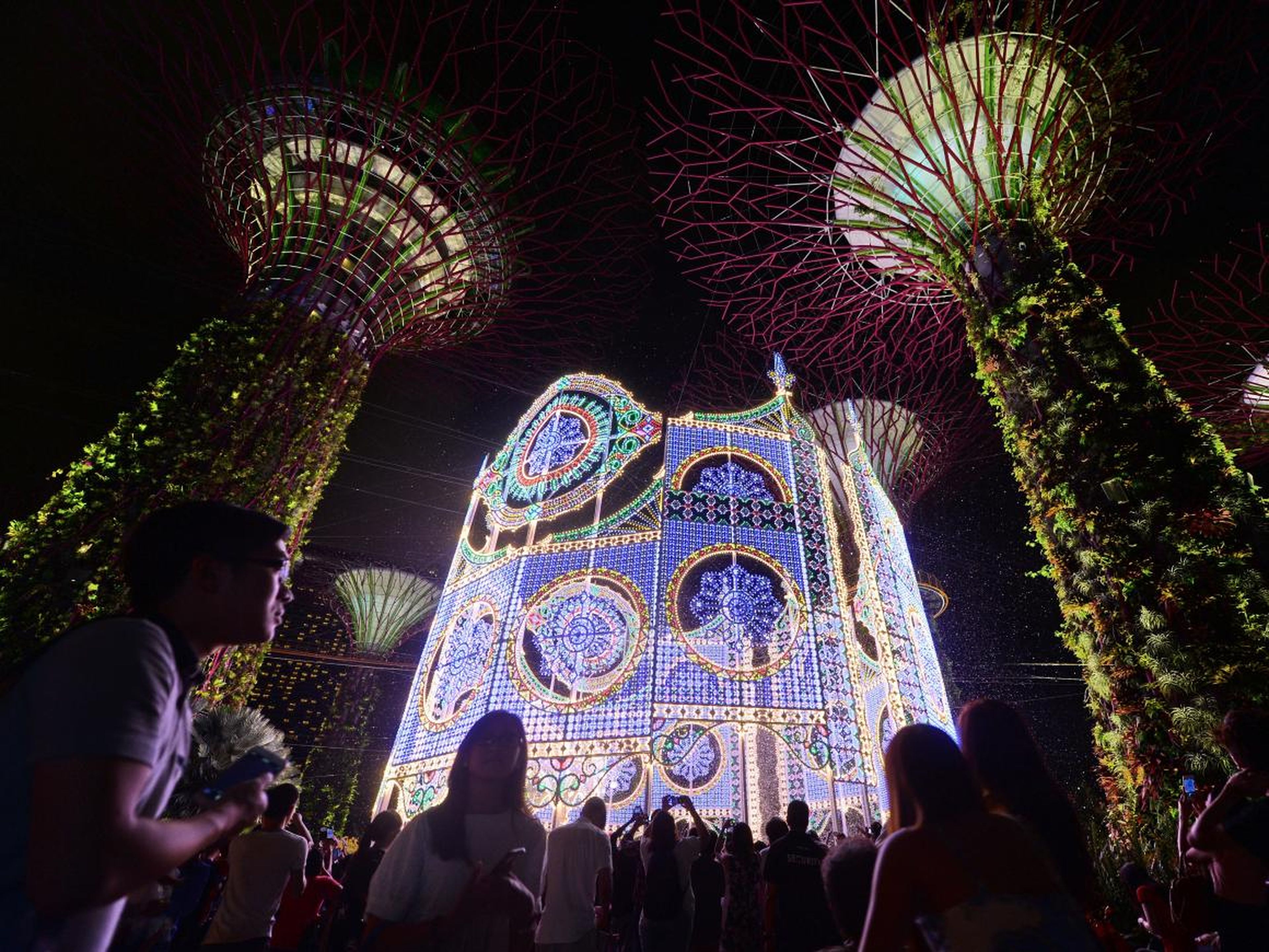 La gente se reúne alrededor de la escultura de luz Luminarie durante el festival de iluminación de Navidad en Garden by the Bay en Singapur el 27 de noviembre de 2015.