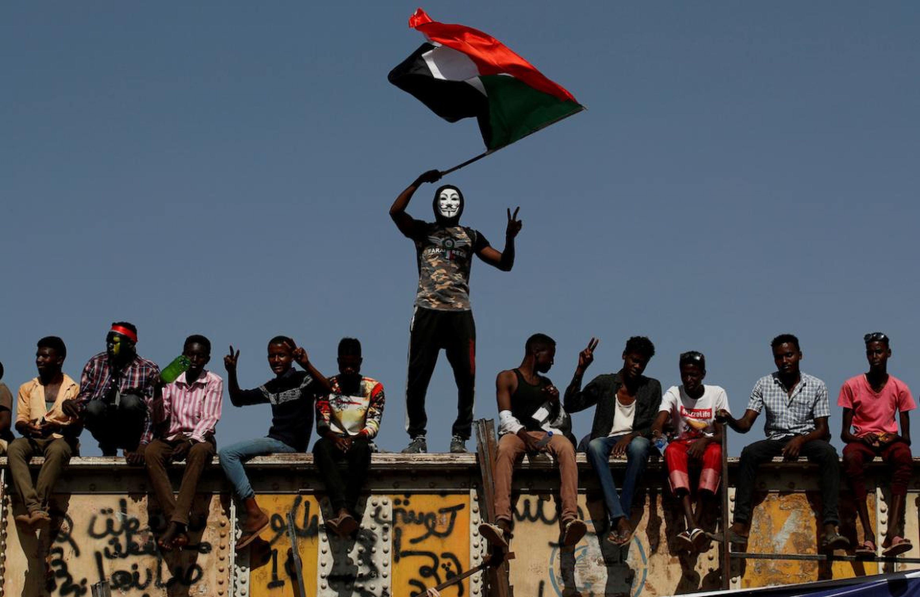 Un manifestante sudanés con una máscara de Guy Fawkes ondea una bandera nacional frente al recinto del Ministerio de Defensa en Jartum, Sudán, el 24 de abril. Las semanas de protestas finalmente provocaron la dimisión de Omar al-Bashir.