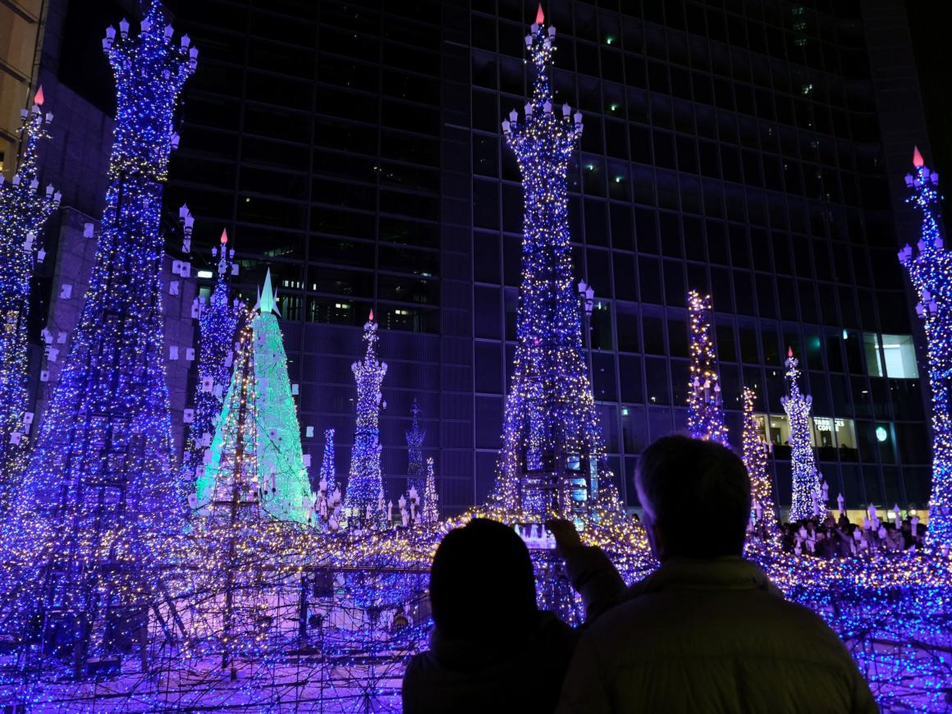 Los turistas admiran las iluminaciones basadas en populares películas animadas de Disney para la temporada de invierno en el centro de iluminación de invierno Caretta Shiodome en Tokio el 16 de diciembre de 2018.