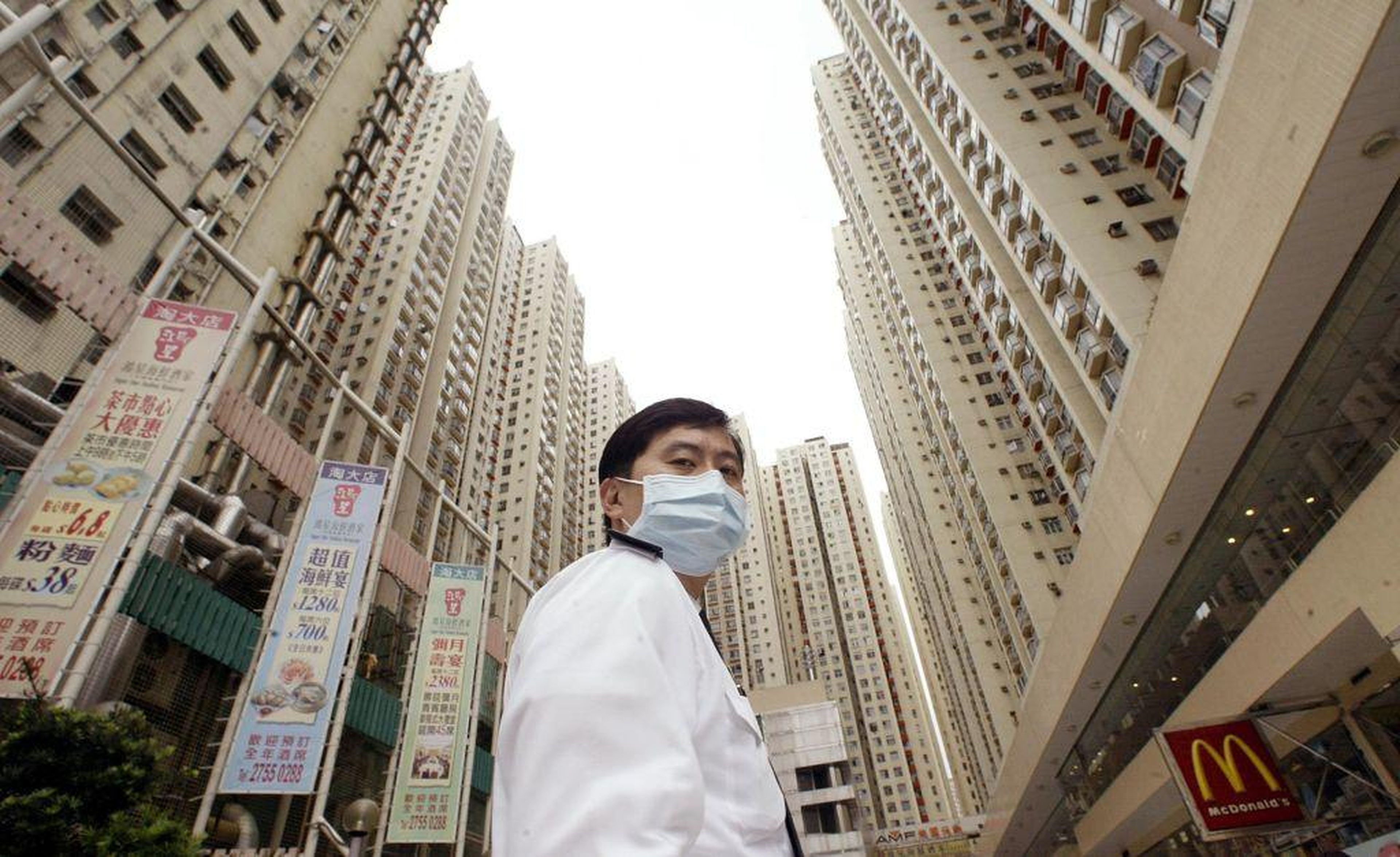 A security guard wears a mask at Amoy Gardens housing estate in Kowloon bay, Hong Kong, where a block was quarantined to protect against a SARS outbreak, April 1, 2003.