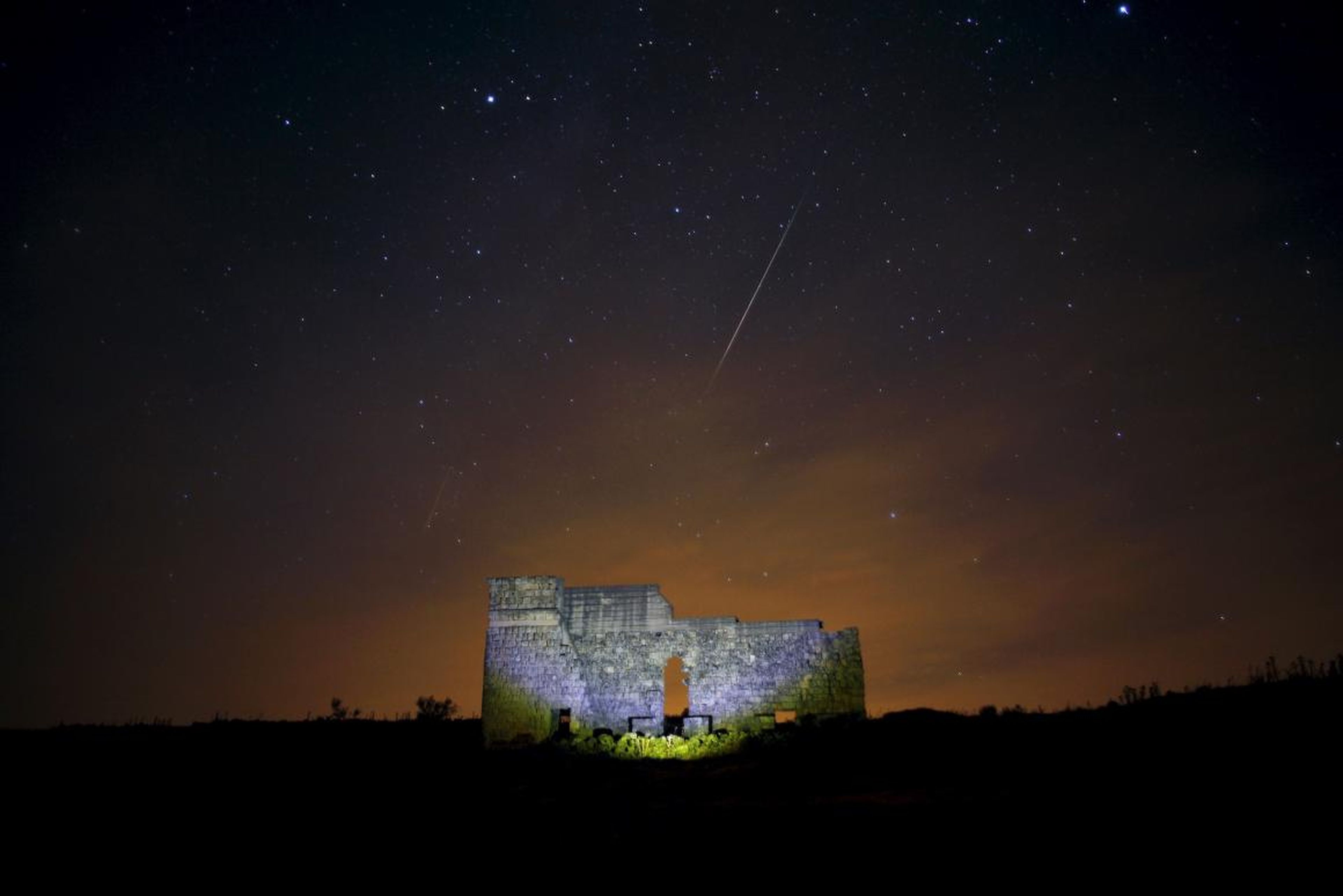 Las estrellas cruzan el cielo sobre un teatro romano en las ruinas de Acinipo, cerca de Ronda, España, durante la lluvia de estrellas Perseida del 13 de agosto de 2015.